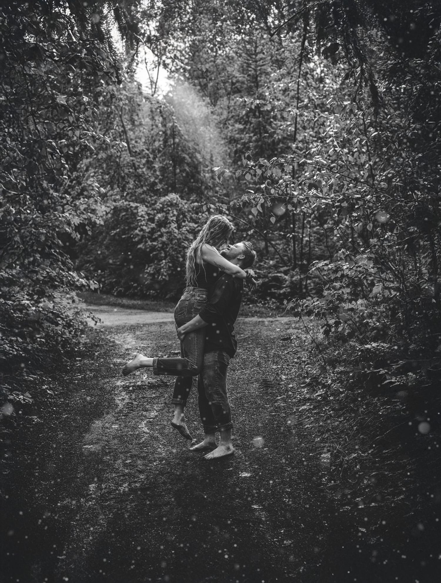 A romantic walk through a wooded path captured in black and white photography.