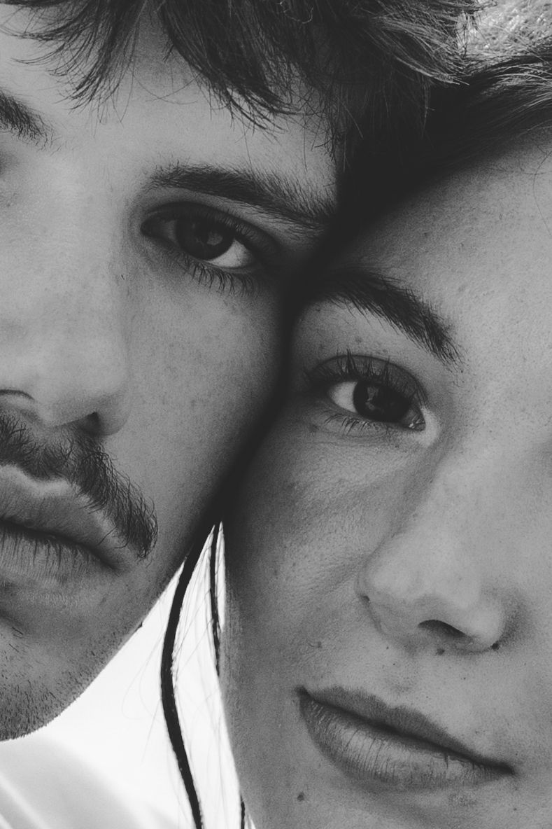 Close-up black and white portrait showing artistic composition and dramatic lighting.