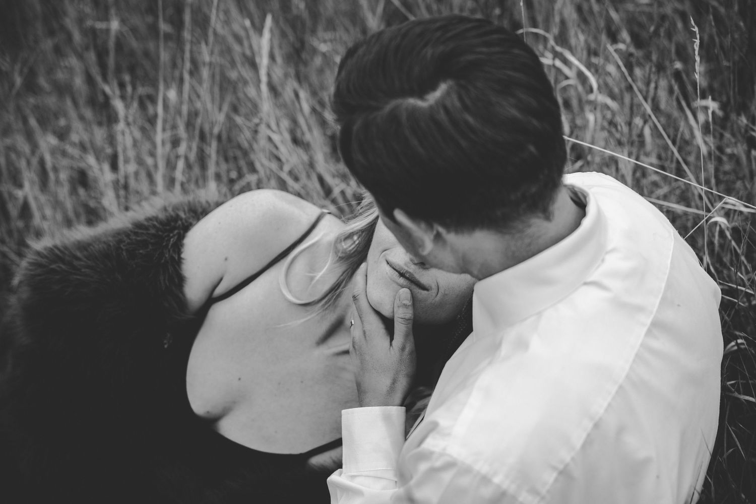 Couple embracing in black and white photograph outdoors.