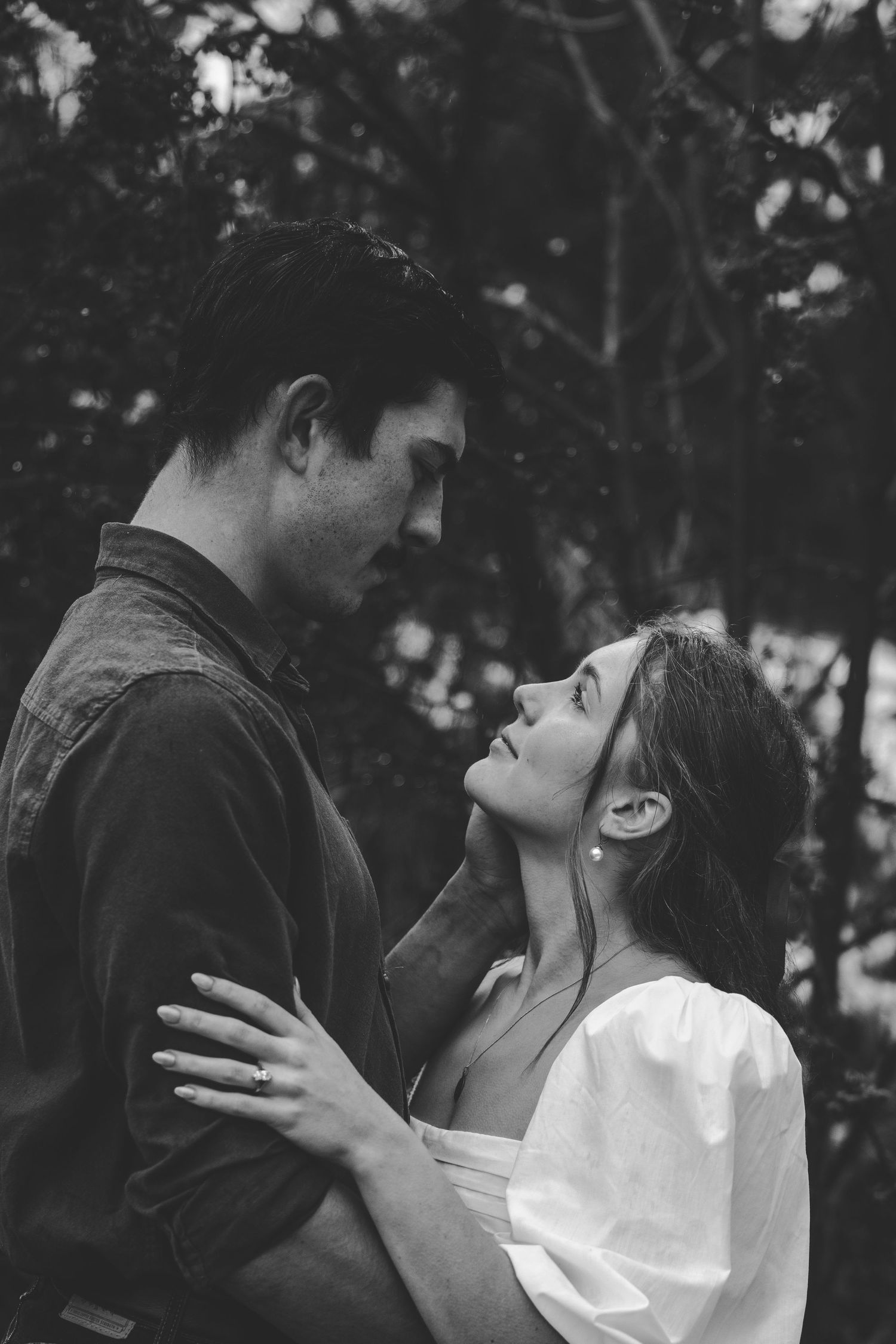 Black and white romantic couple portrait series showing intimate moments in an outdoor setting.
