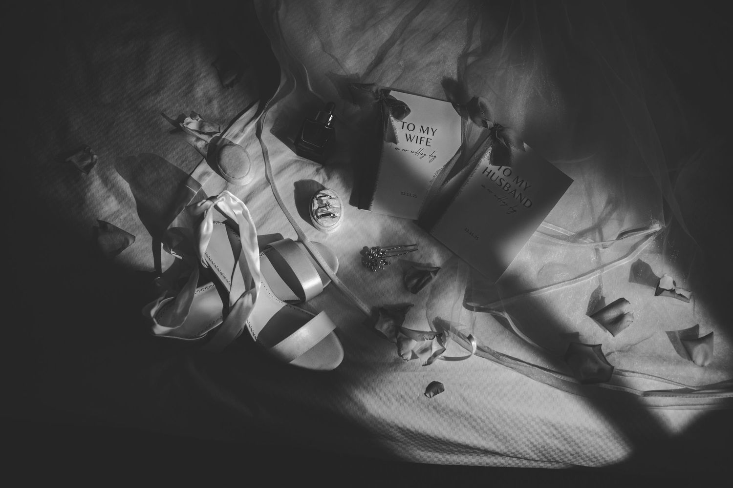 Dramatic low-key lighting on wedding shoes creating artistic shadows and highlights.