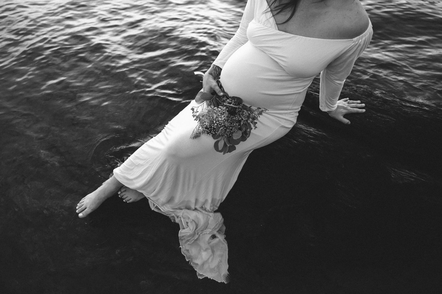 Black and white image of flowing white dress floating in rippling water.