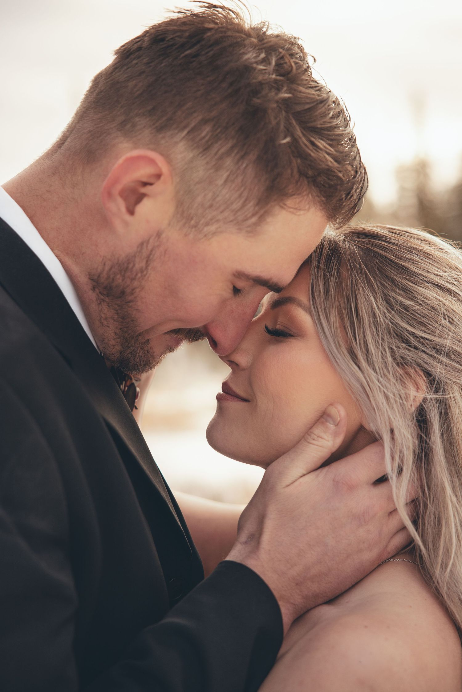 Intimate close-up wedding portrait showing tender moment between newlyweds.