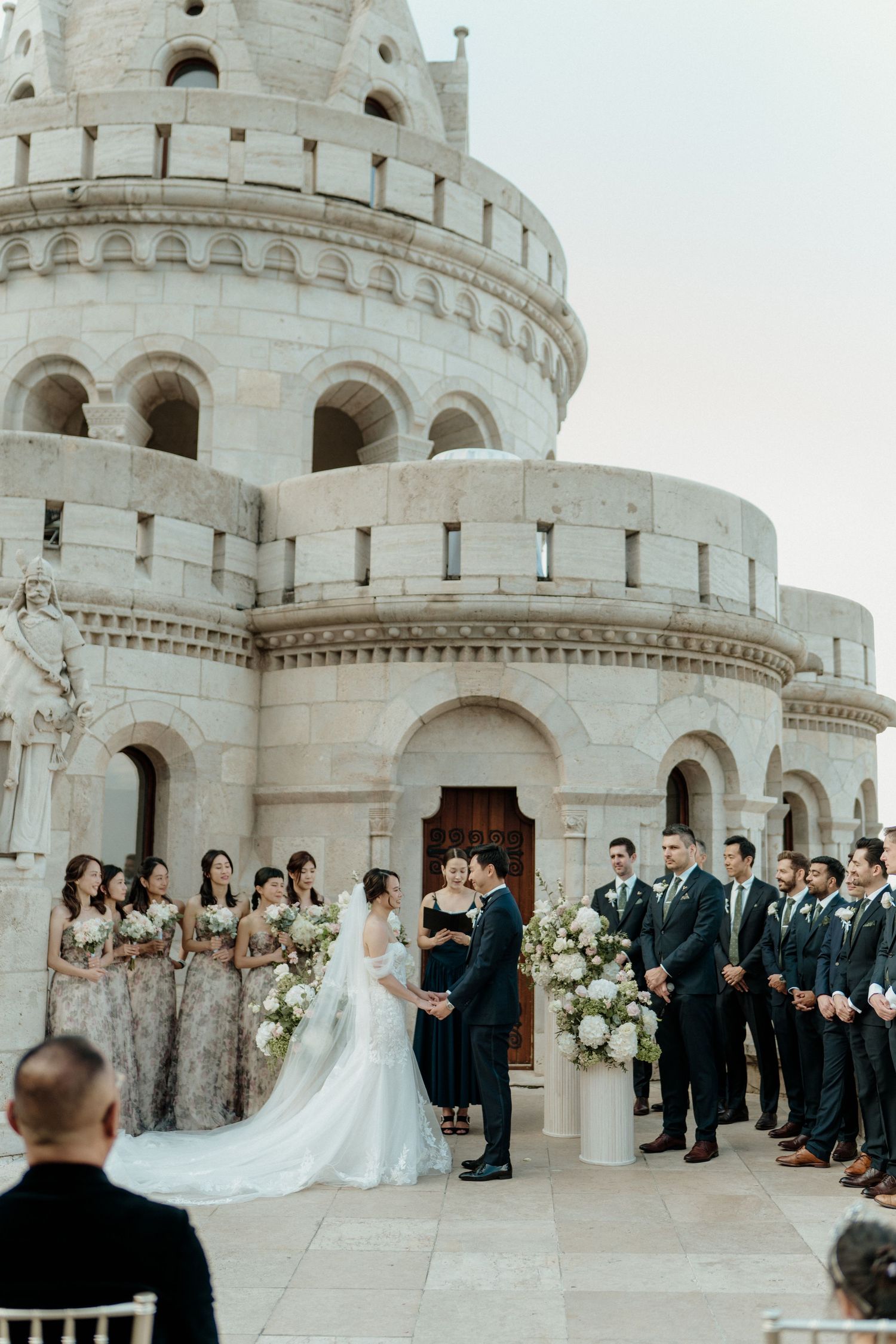 Wedding ceremony at Fisherman's Bastion Budapest with bridesmaids and groomsmen flanking couple.