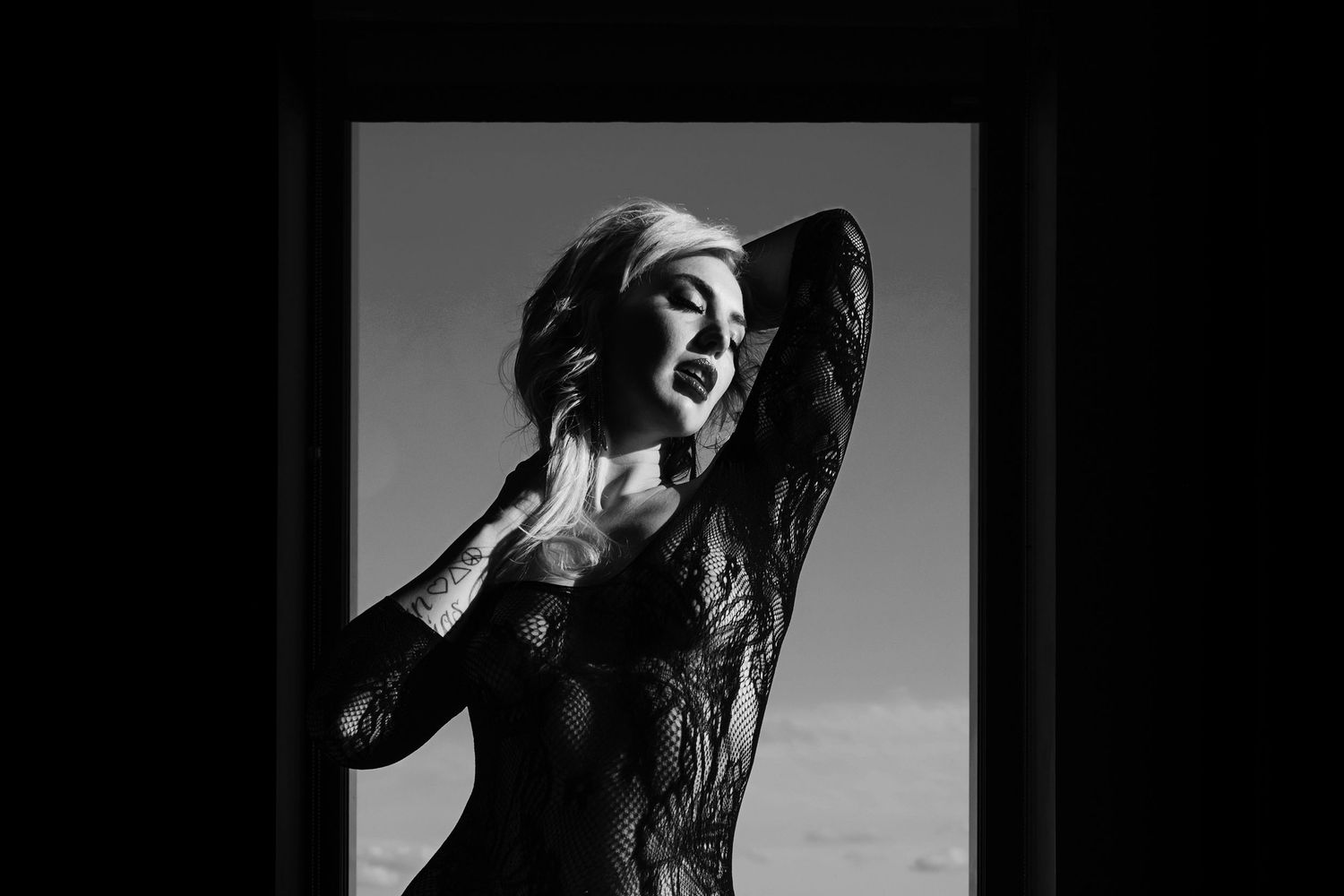 A dramatic black and white portrait of a dancing figure in elegant lace against a dark background.