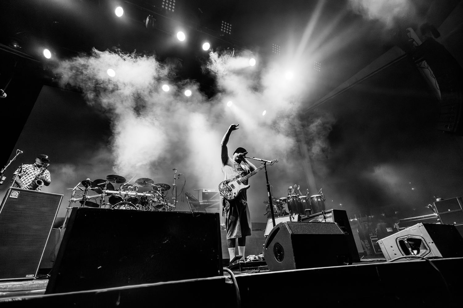 Dramatic silhouette of performer on stage with bright lights and smoke effects.