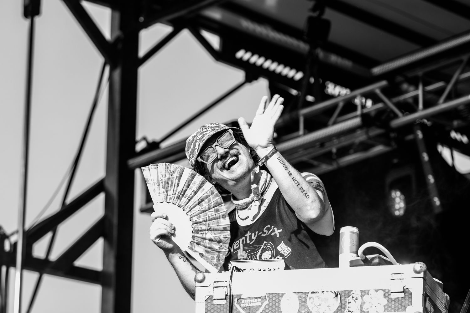 Black and white photo of a performer using a hand fan during an animated stage performance.