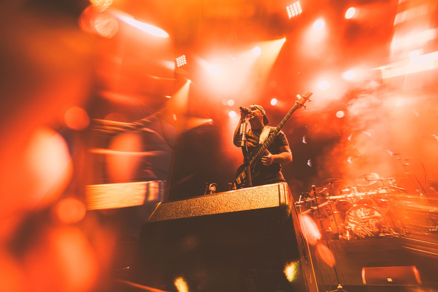 Concert performance captured through red stage lights with dramatic bokeh effects.
