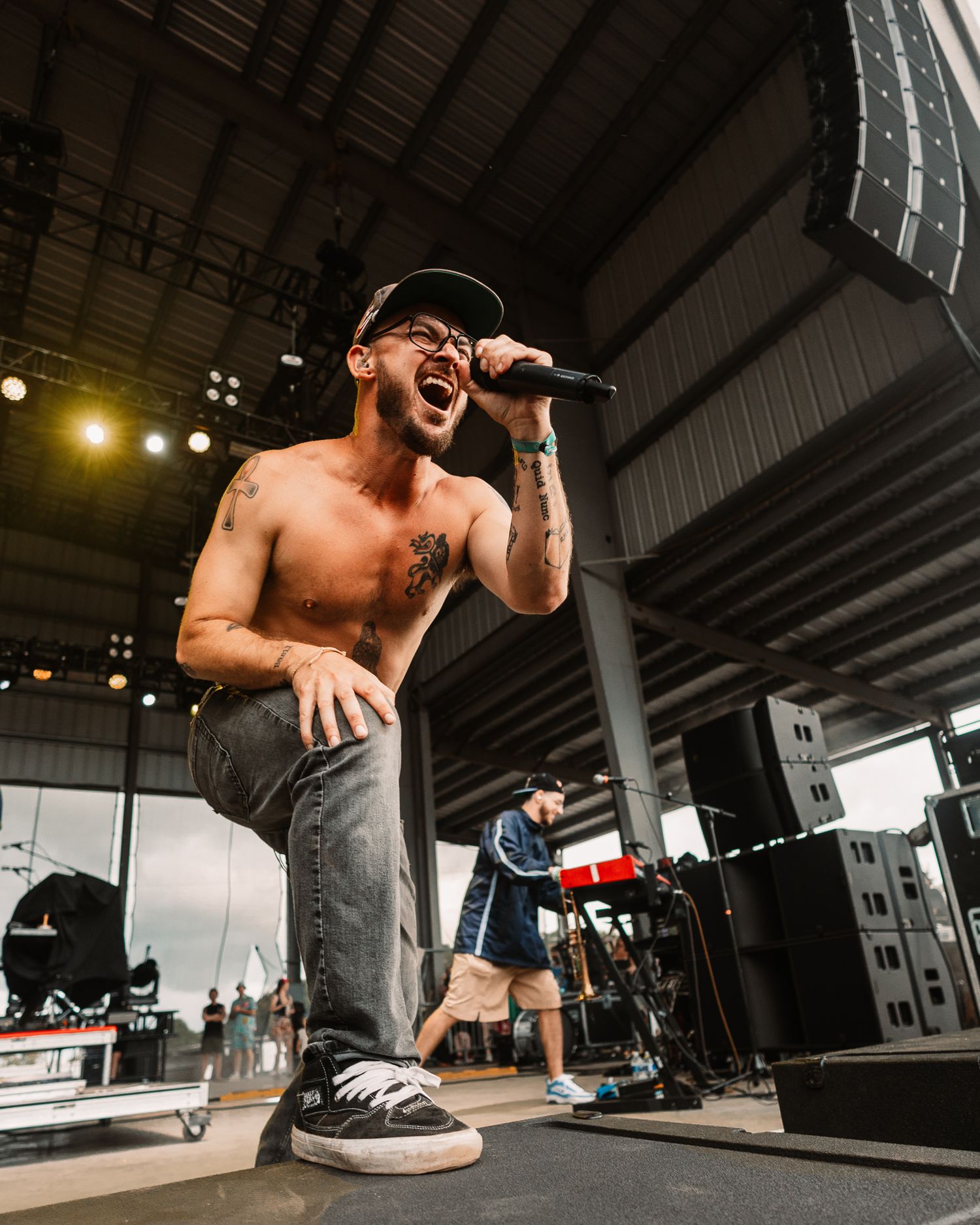 Energetic performer singing on stage during a live concert performance.