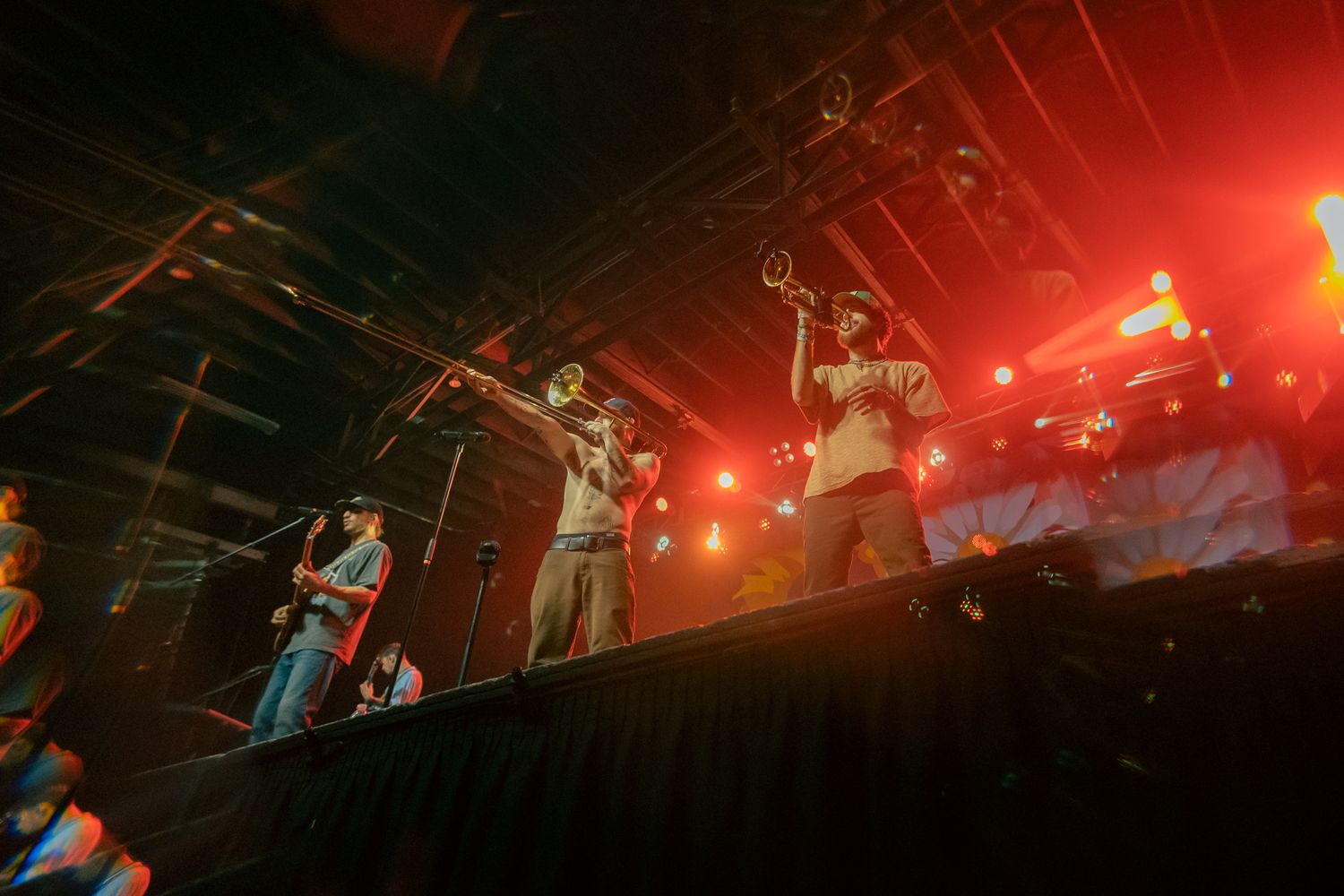 Musicians performing on stage with dramatic red lighting and theatrical atmosphere.
