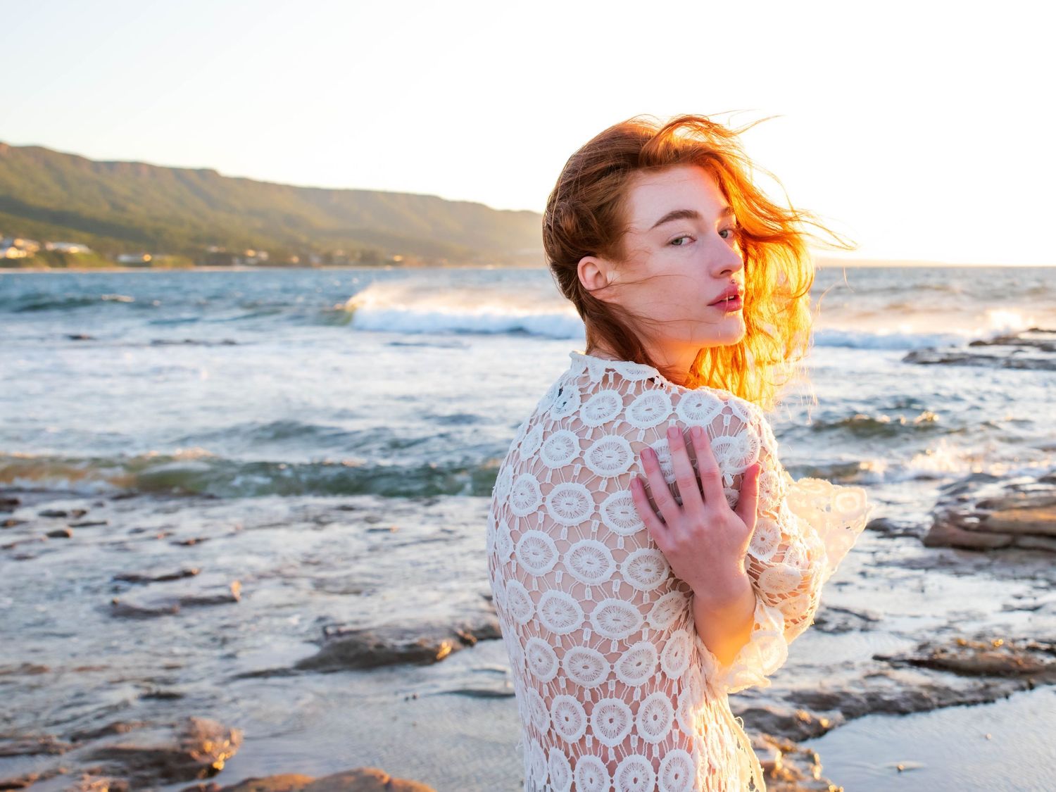 Sunset beach portraits with flowing lace dress and warm golden lighting.