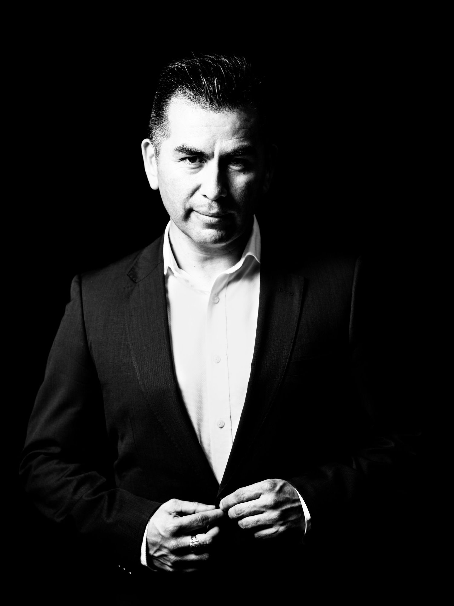 Professional black and white portrait series showing a person in formal attire using a mobile phone.