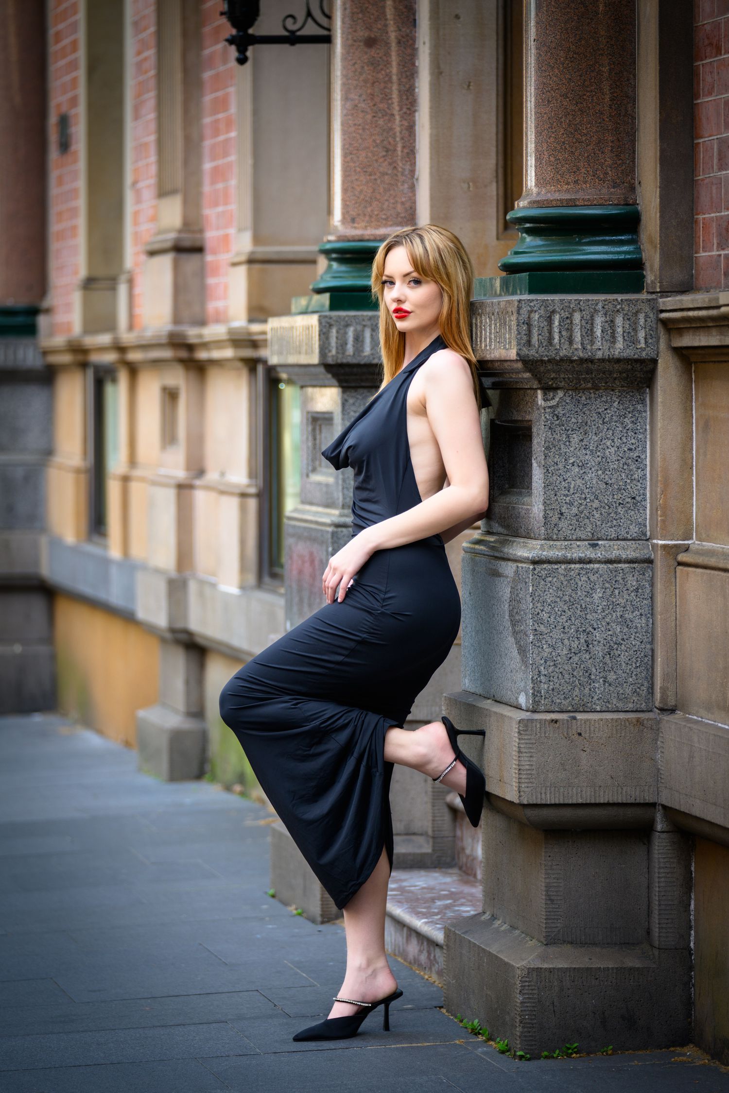 Lifestyle portrait against historic building facade with ornate architectural details.
