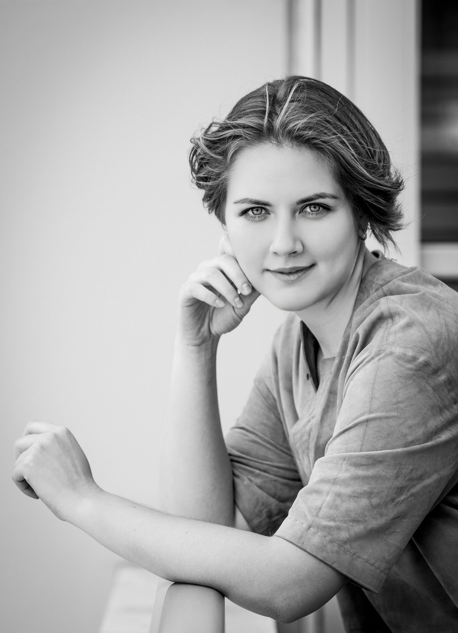 Black and white portrait series showing soft expressions and gentle poses against a light background.