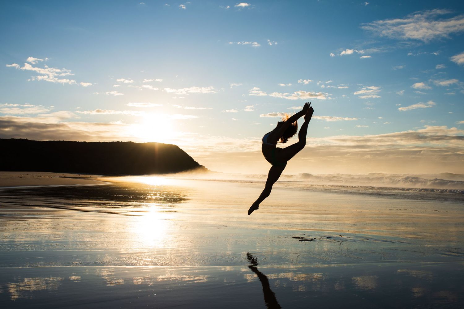 Silhouetted figures perform graceful dance moves against a sunset beach panorama.