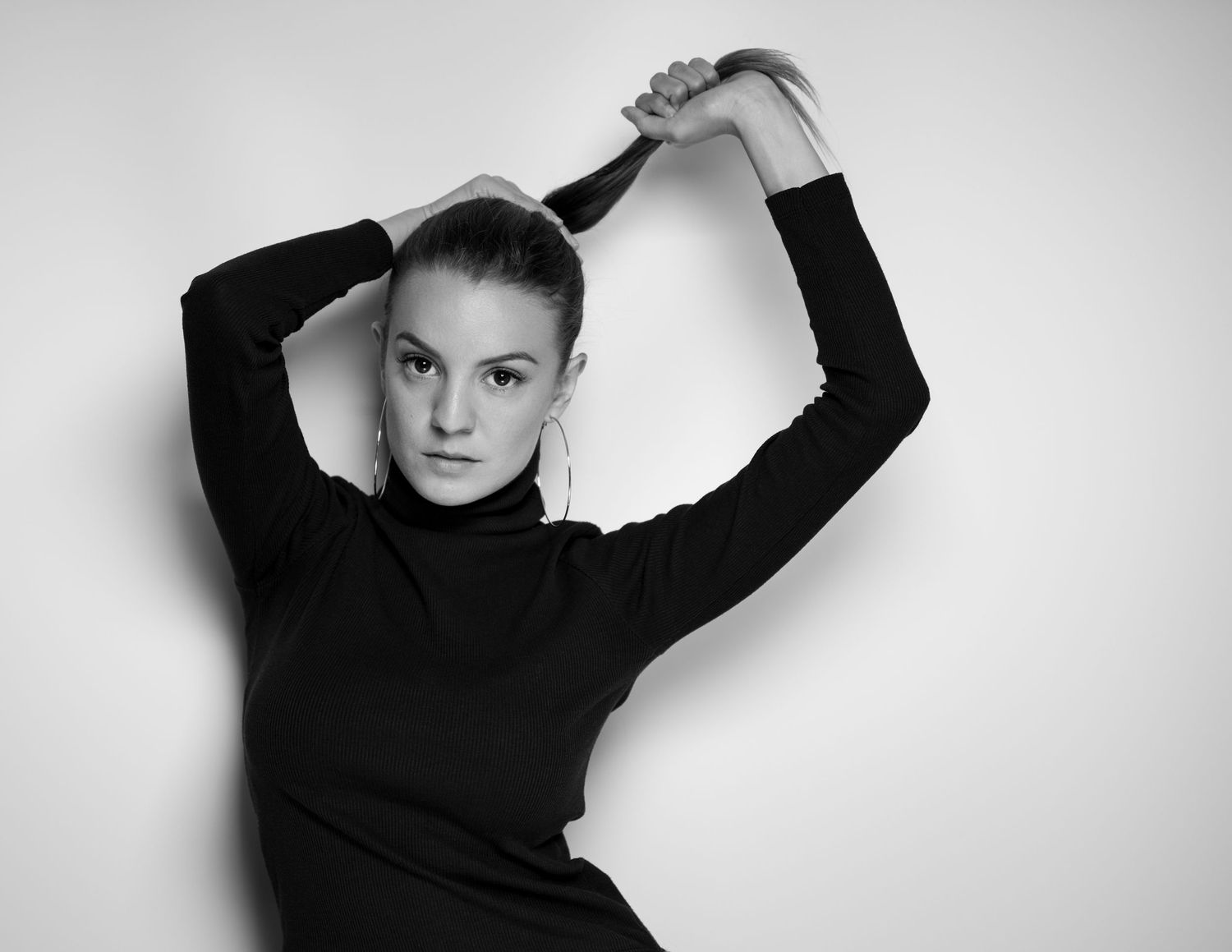 High contrast monochrome portraits showing dynamic poses in black attire.