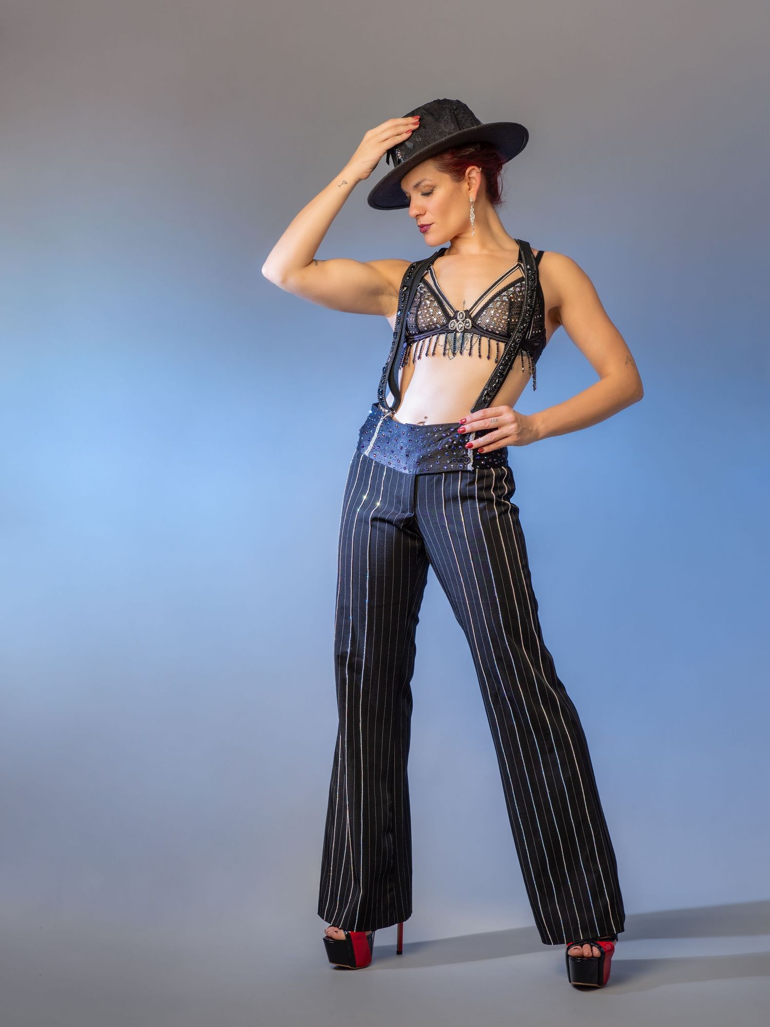 Fashion photo series showing pinstripe jumpsuit poses against blue background.