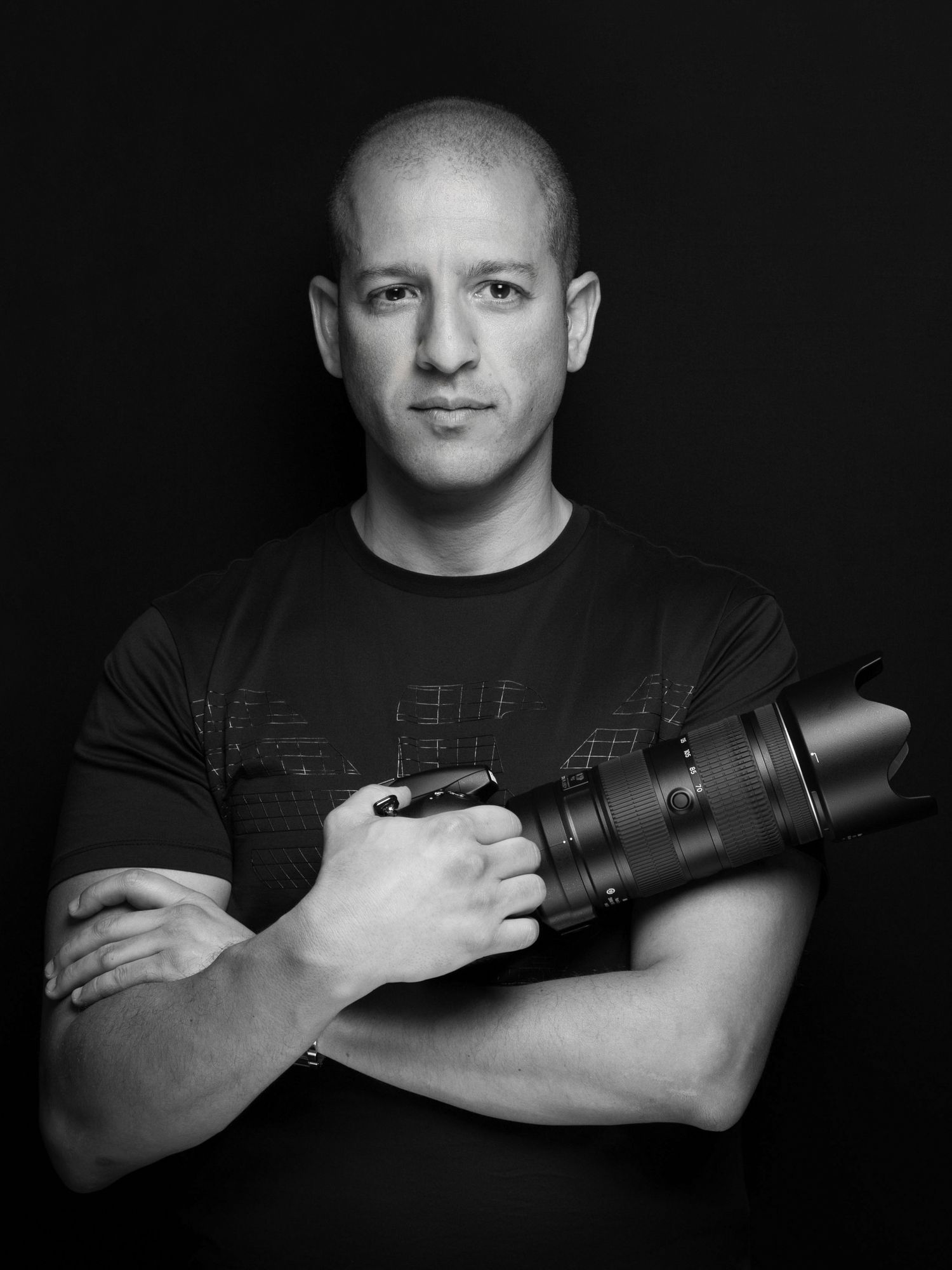 Black and white portraits of a photographer posing with professional camera equipment.