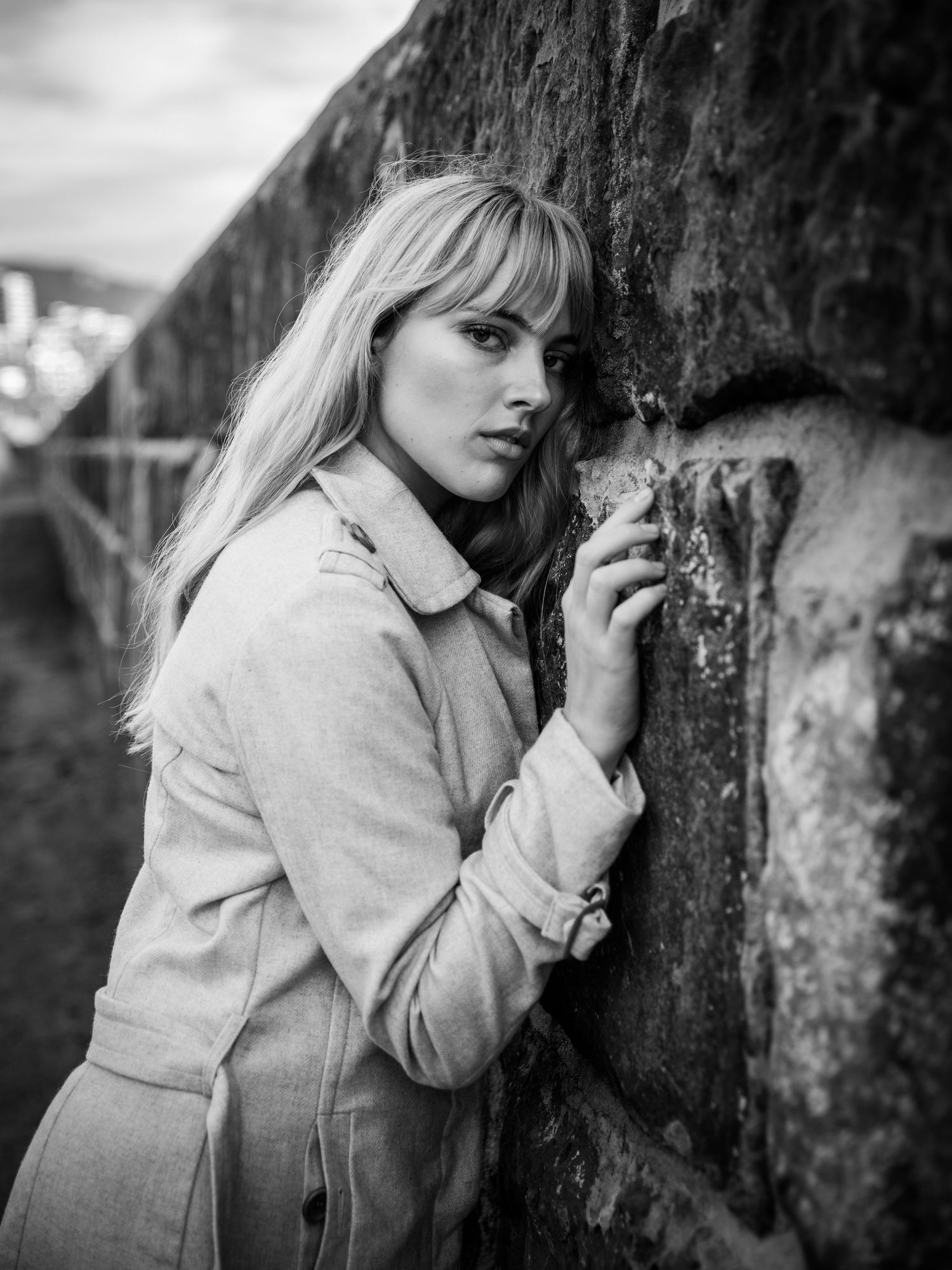 Black and white portrait series showing contemplative poses against textured wall.