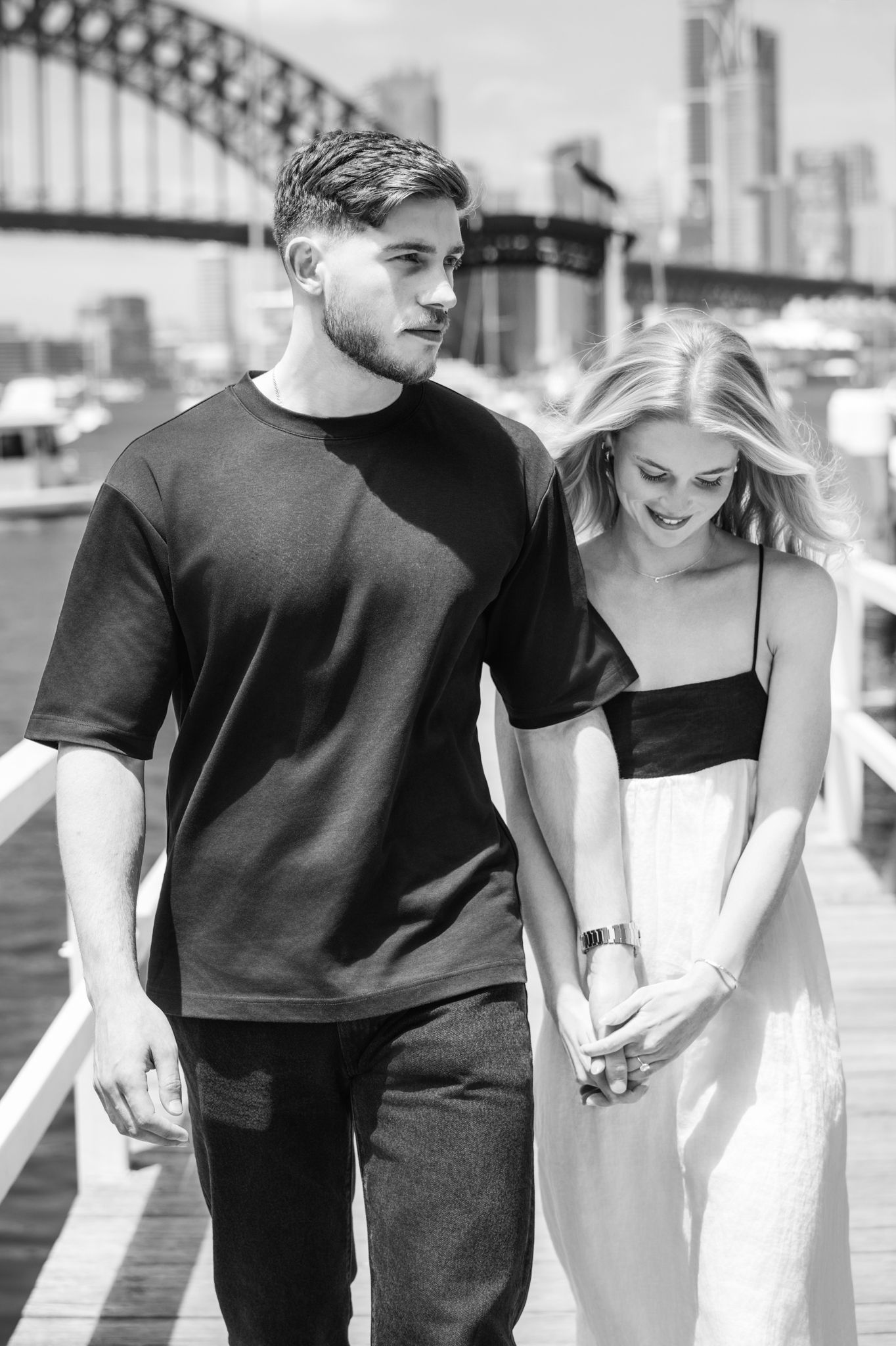 Black and white urban couple portraits walking together near city architecture.