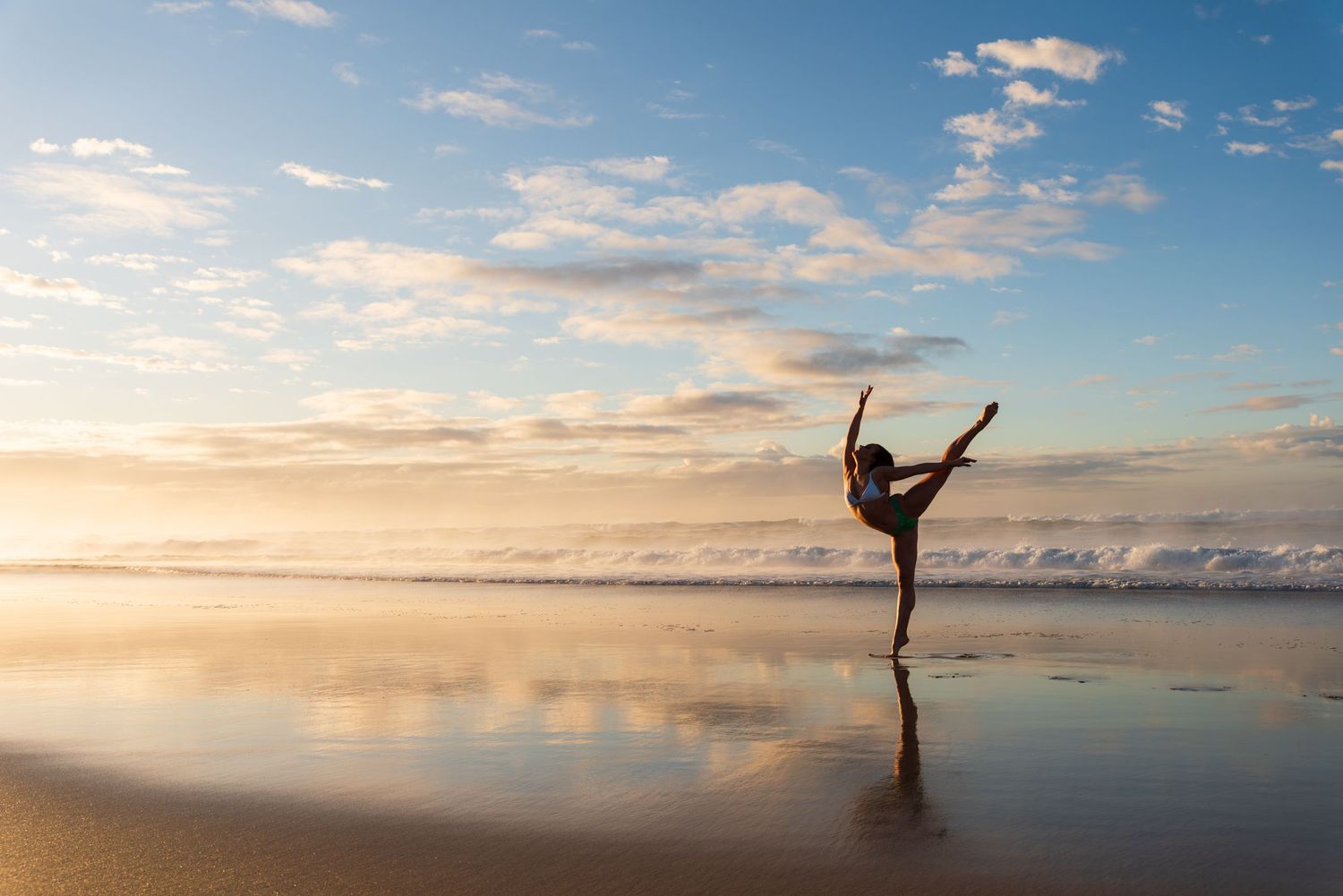 Dancer strikes elegant poses on reflective beach surface during golden hour.