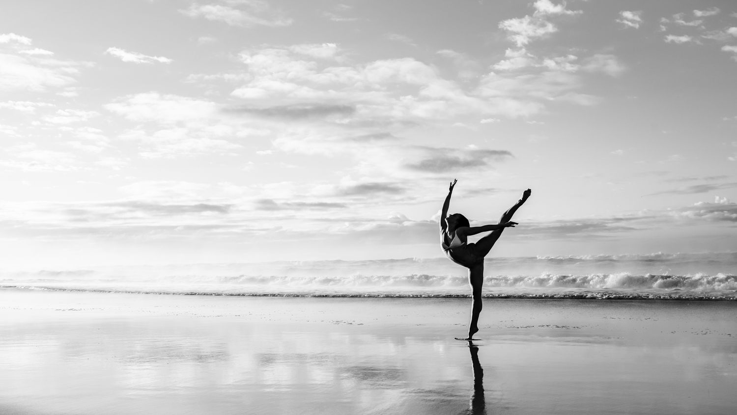 Silhouettes of dancers performing graceful moves against a sunset sky.