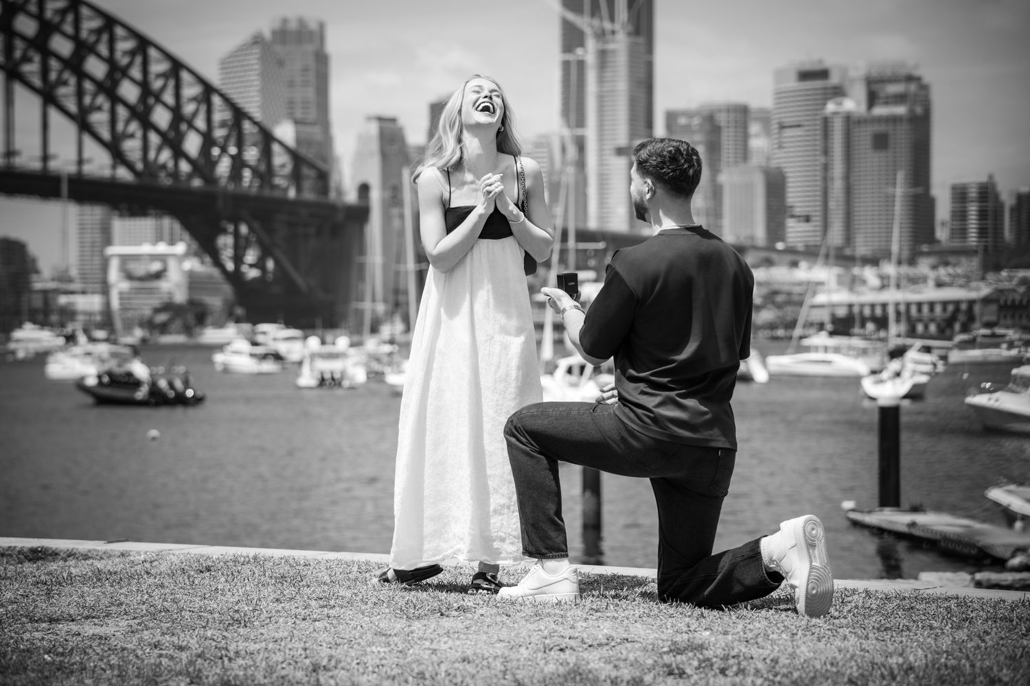 Black and white engagement photos with urban architecture and waterfront scenery.