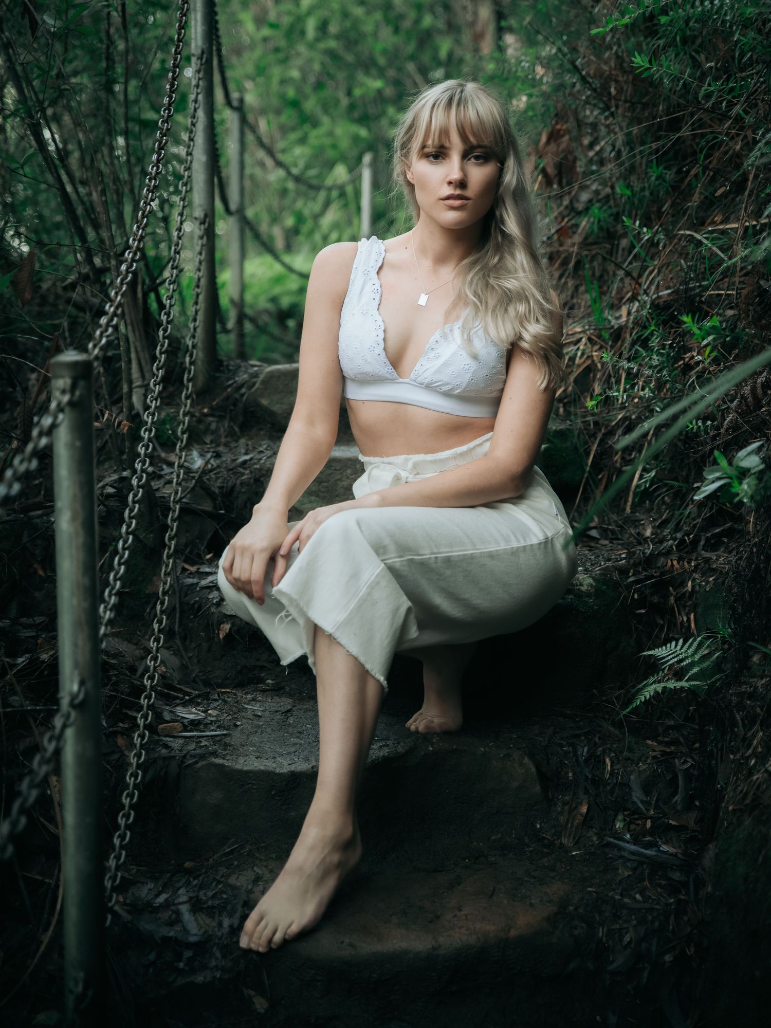 Artistic portraits in garden setting with moody lighting and natural elements.