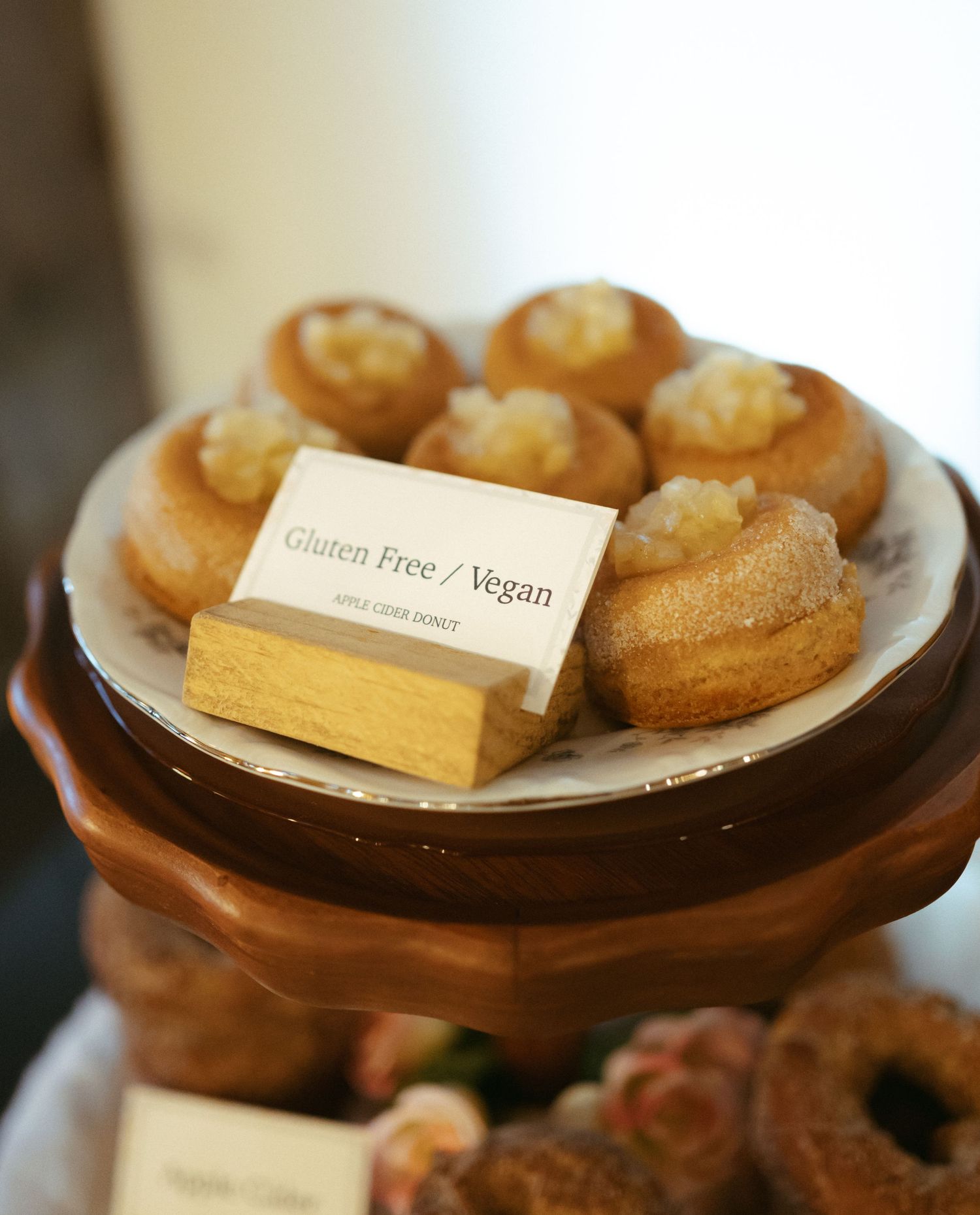 Close-up view of golden pastries arranged on wooden serving plates with small labels indicating gluten-free options.