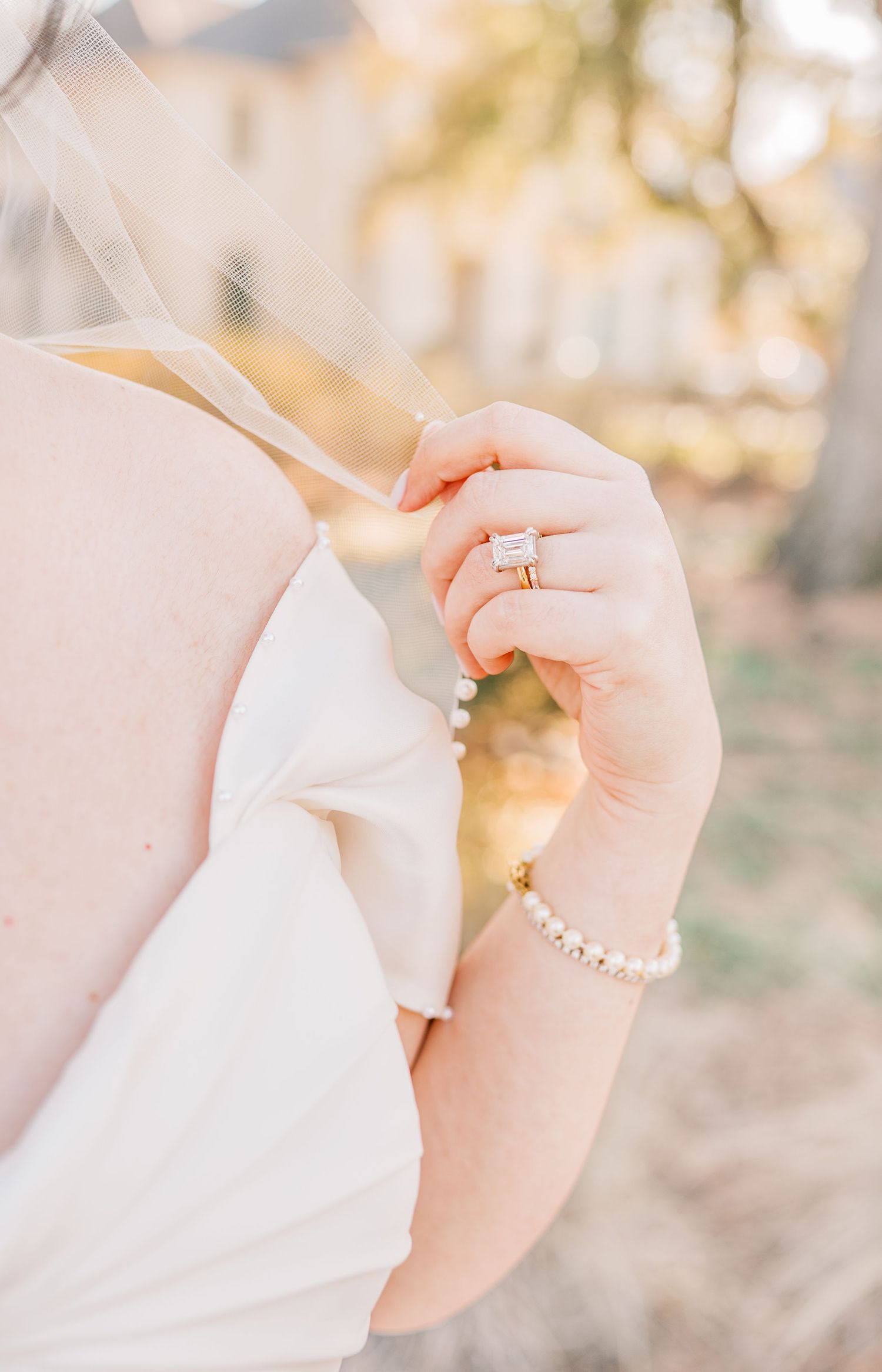 Close-up view of hands holding and tearing delicate white tissue paper against a soft blurred background.