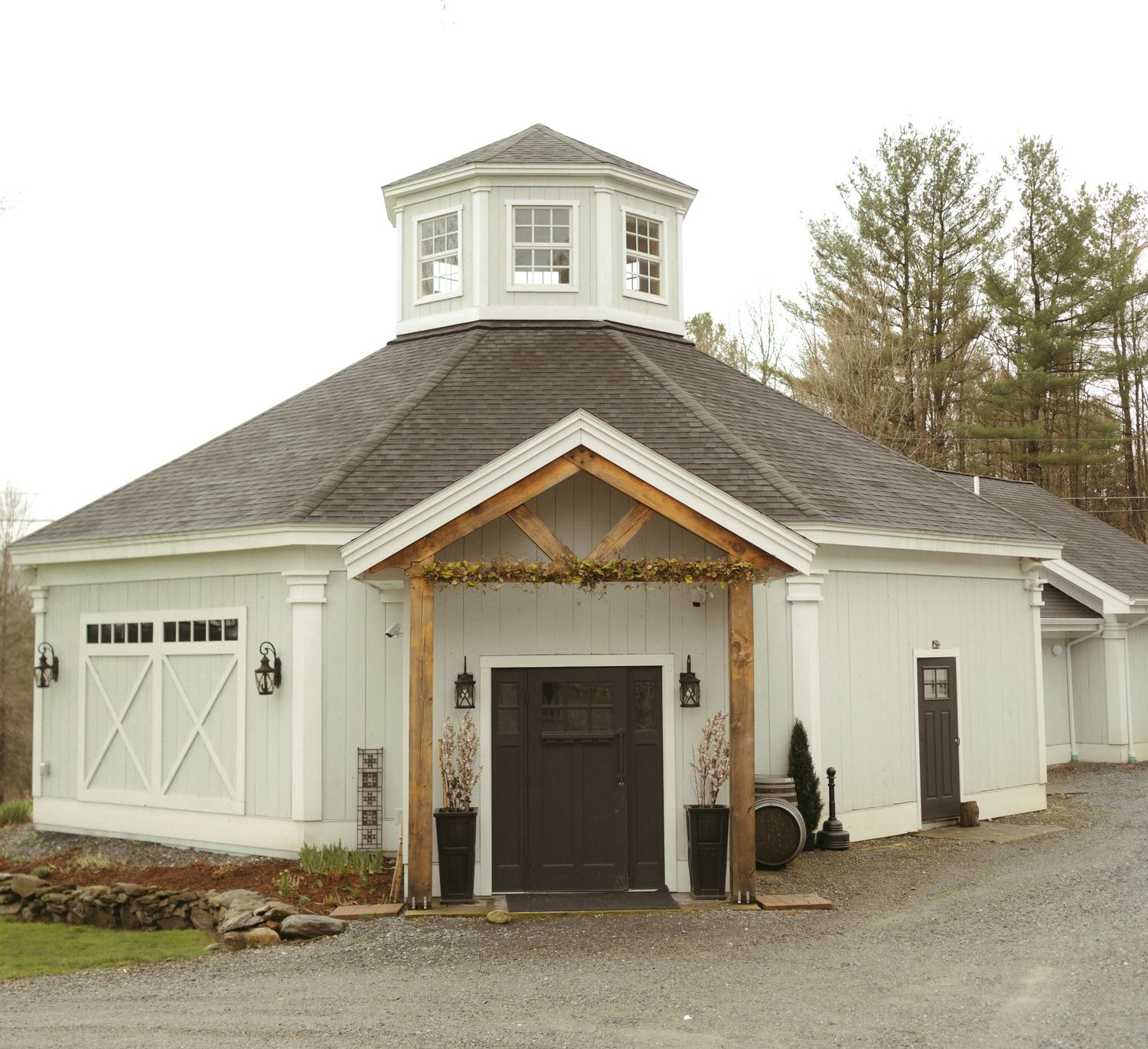 A panoramic view of multiple white garage doors and building exteriors with rustic architectural details.