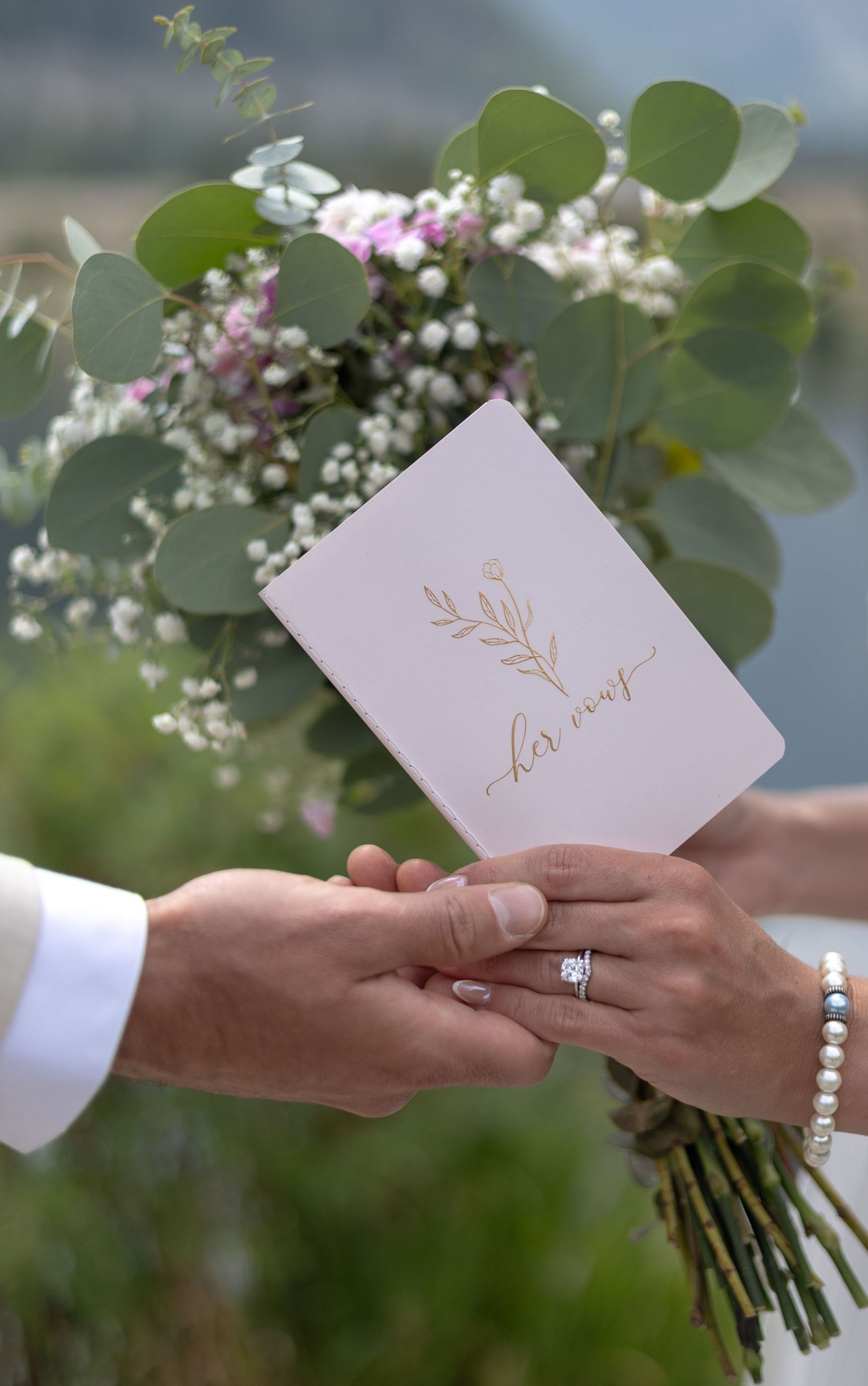 Close-up shots of hands exchanging love notes with delicate floral bouquets and wedding rings in an outdoor setting.