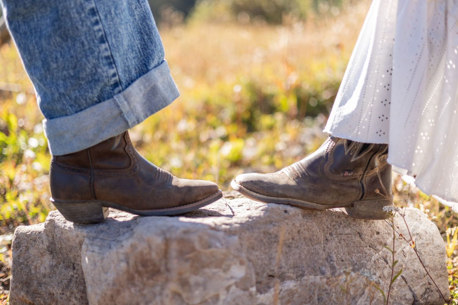 Close-up sequence of brown leather boots stepping on stones in a natural outdoor setting.