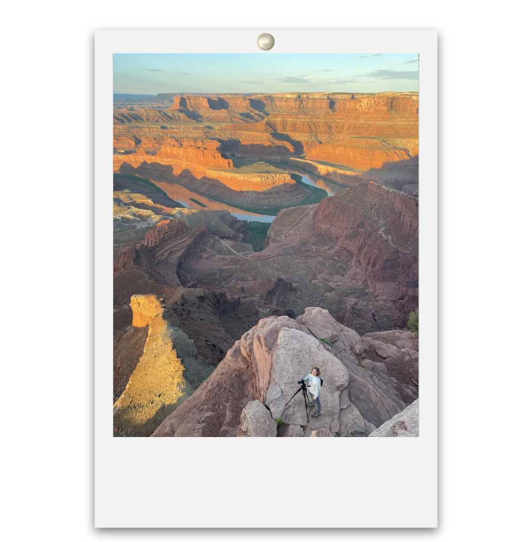 Aerial view of the Grand Canyon at sunset with a climber on rocky cliffs above the Colorado River.