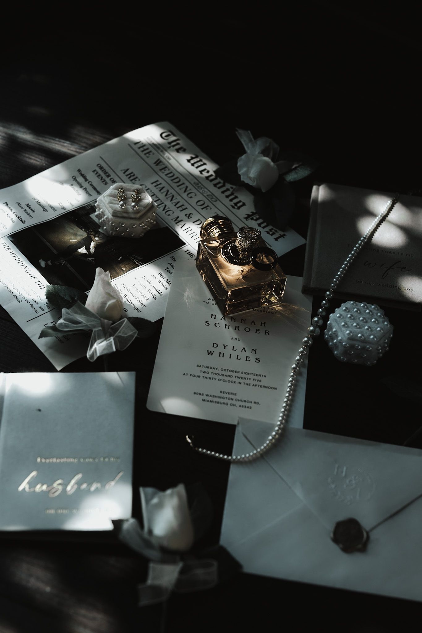 Wedding stationery and invitation details arranged artistically in moody lighting.