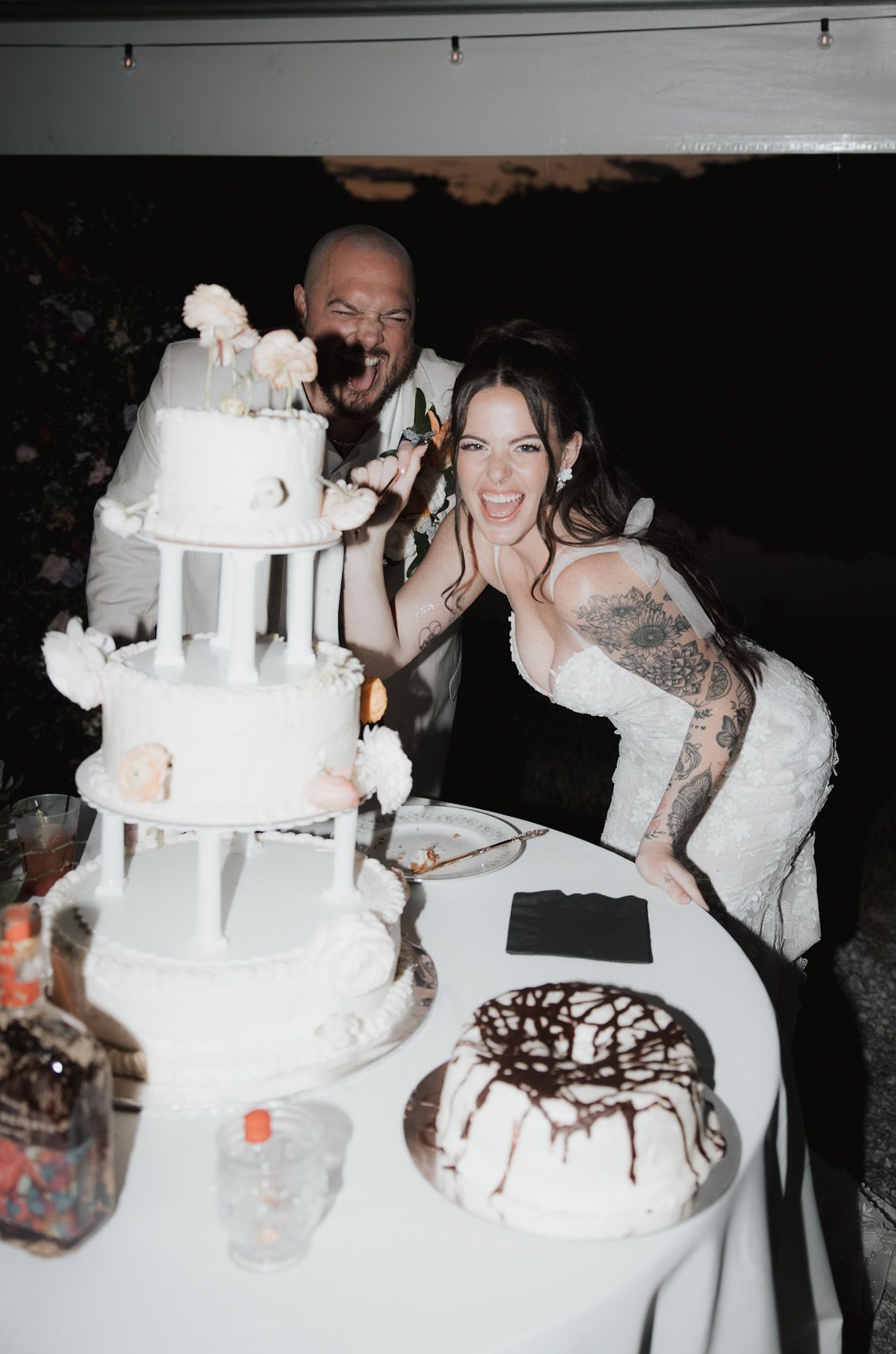 Wedding reception scene with elaborate white tiered cakes decorated with castle-like designs.