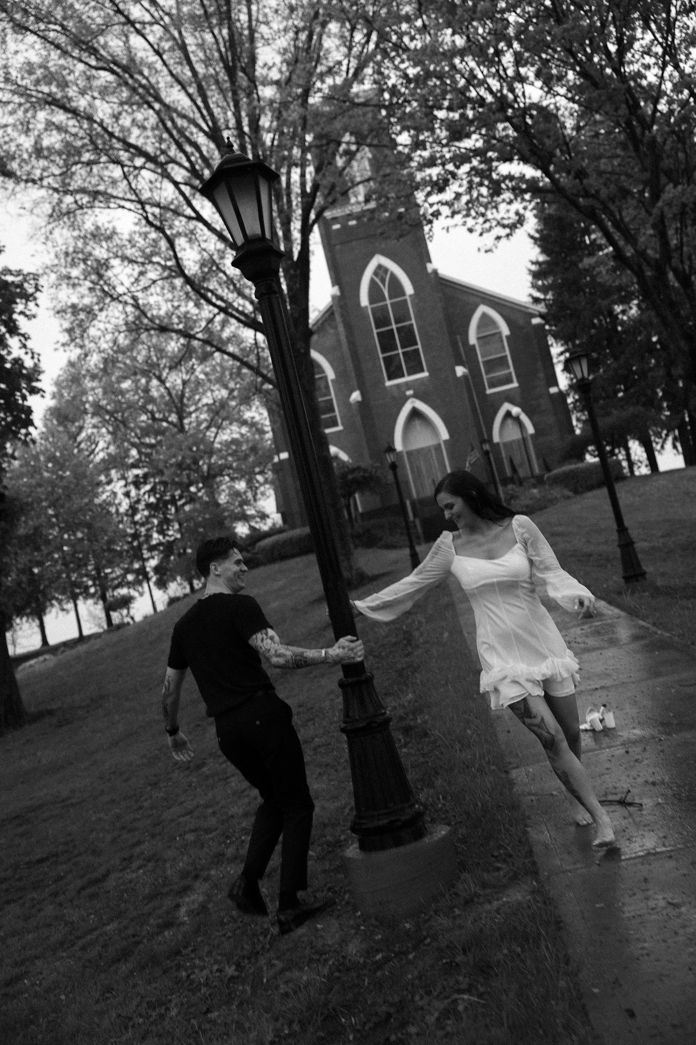 Playful wedding photography sequence on a grassy hill with a church in the background.