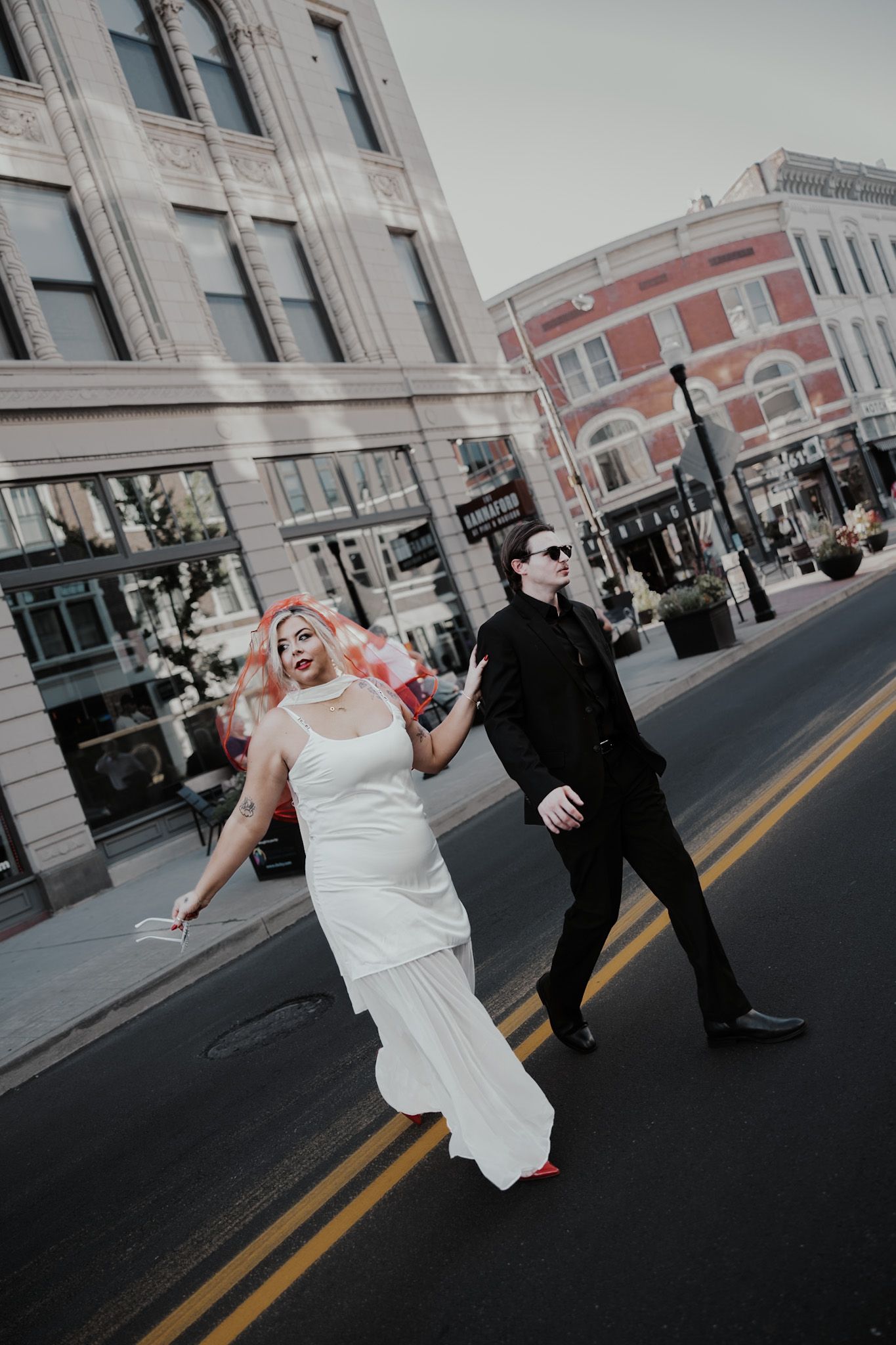 Dynamic street photos of a couple celebrating their wedding day in an urban setting.