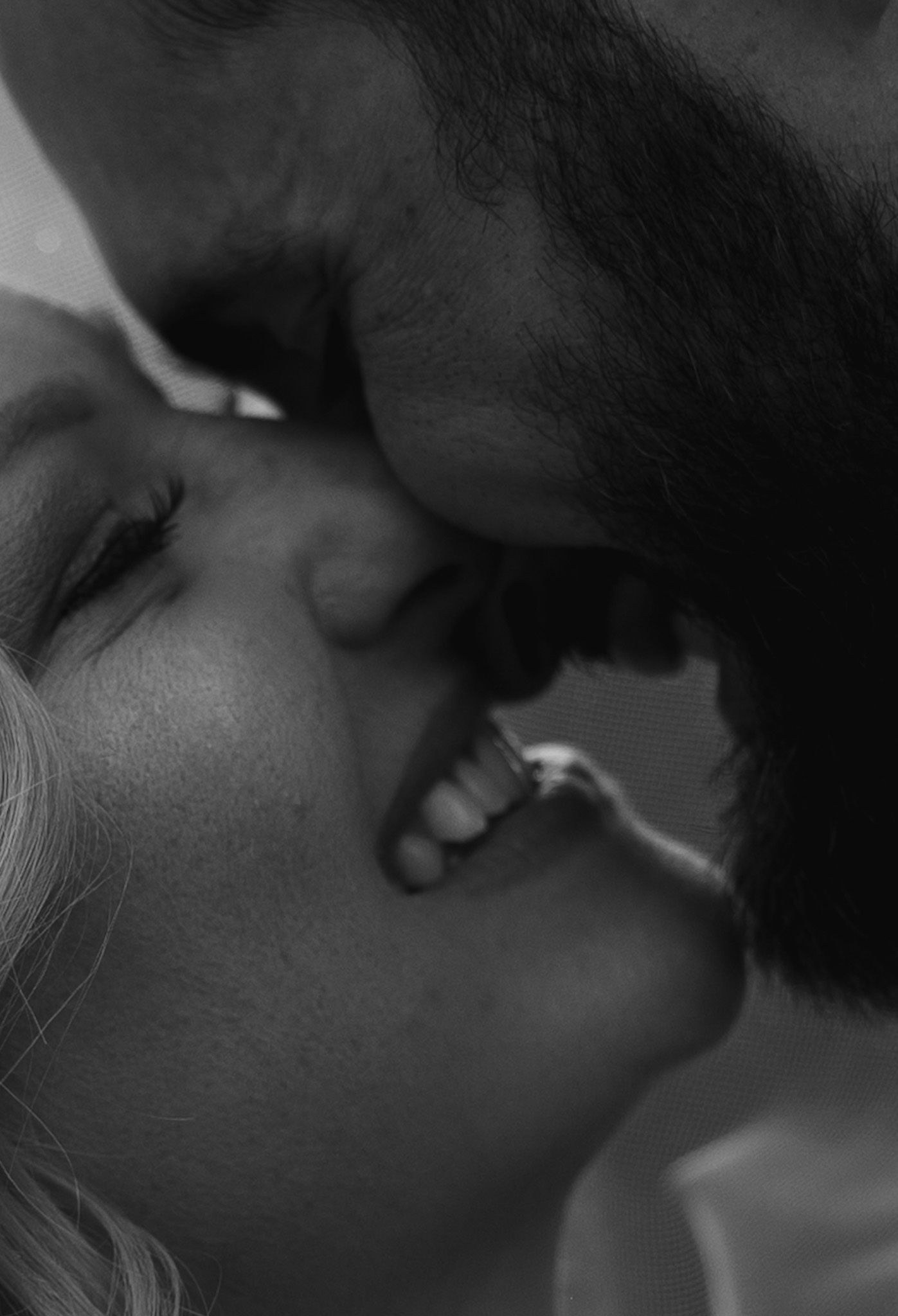Intimate black and white close-up sequence of a romantic wedding moment.