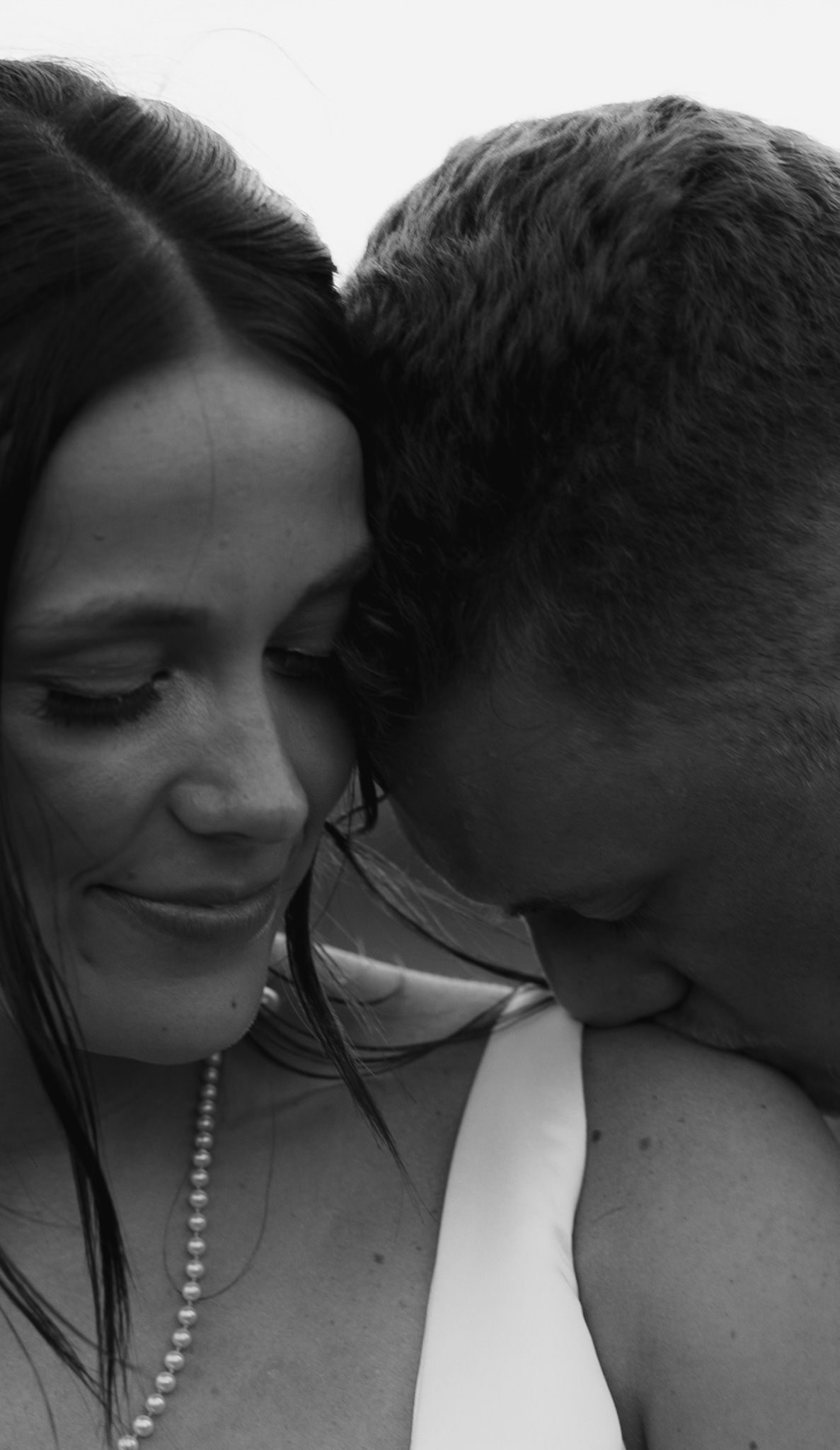 Intimate black and white close-up portraits showing tender romantic moment.