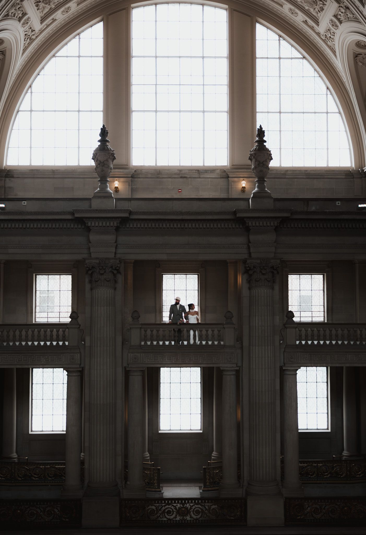 A grand architectural interior with arched windows and classical columns in natural light.