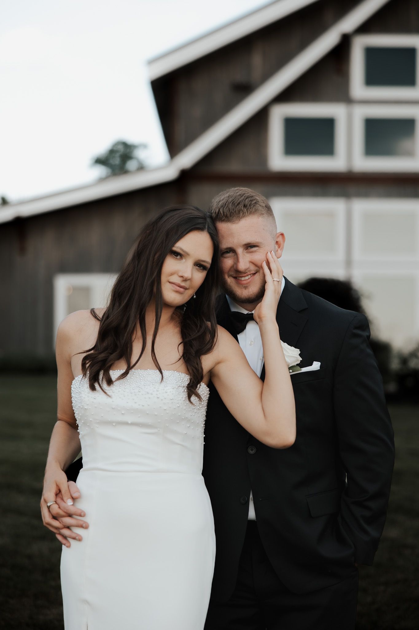 Wedding portraits captured against a modern farmhouse exterior.