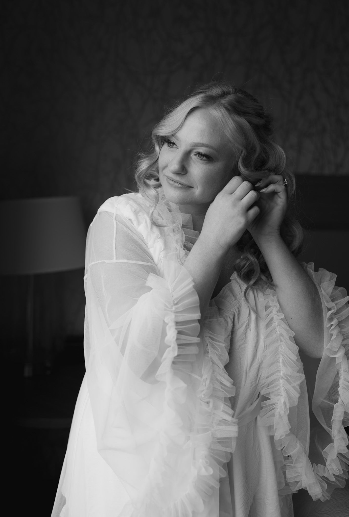 Black and white portraits of someone in a delicate ruffled white garment.
