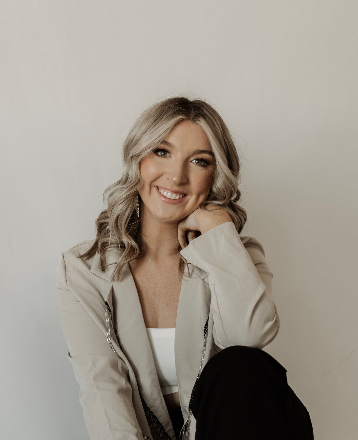 Fashion portraits in beige blazer against minimal studio backdrop.
