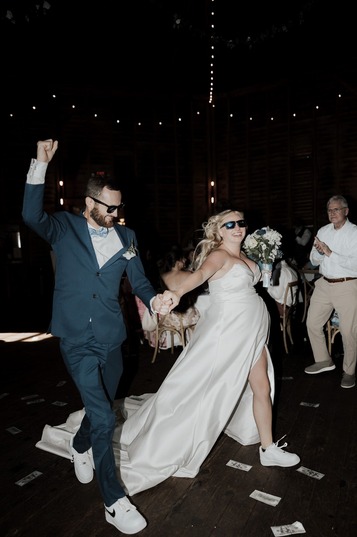 Wedding reception dance sequence showing couple in white dress and blue suit having fun.