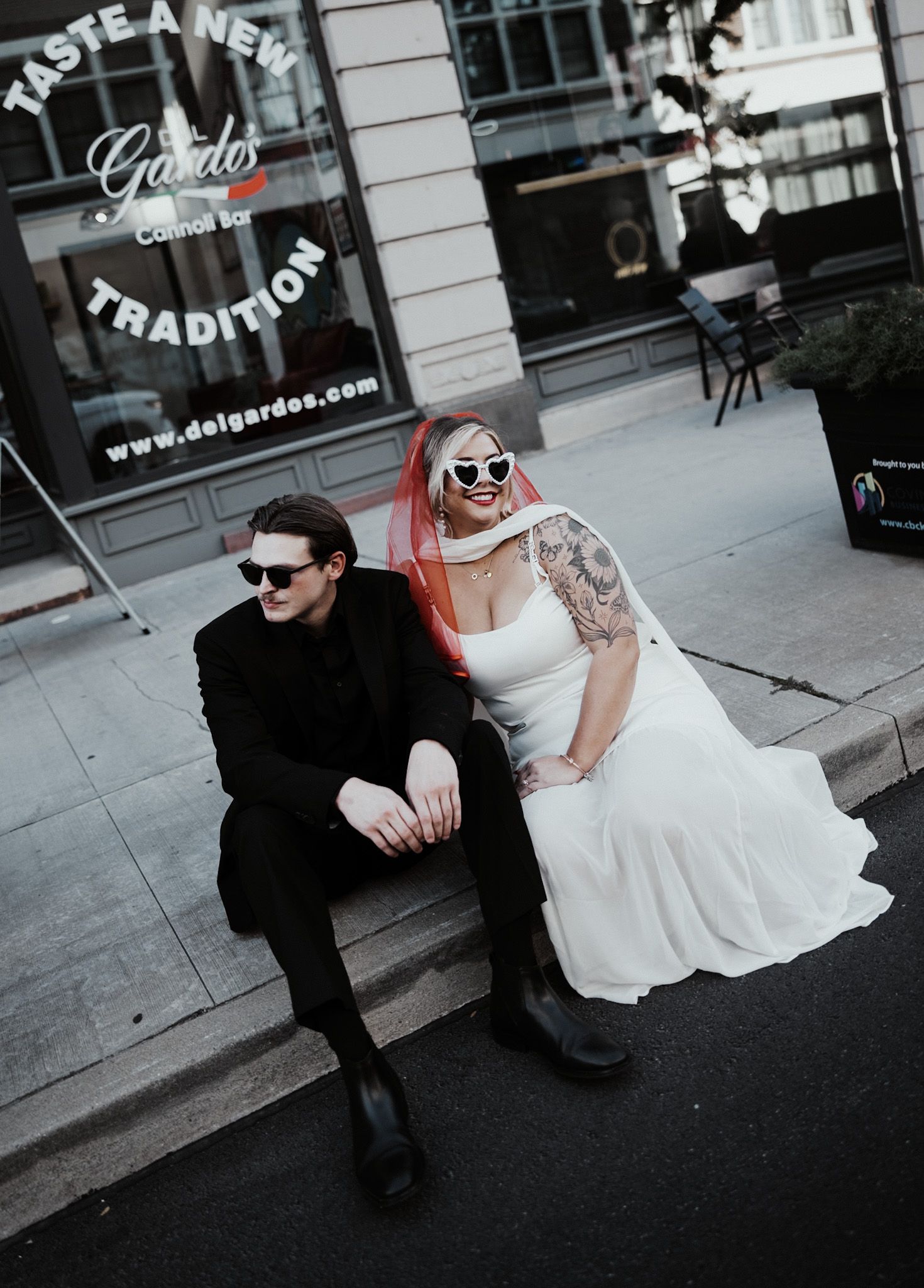 Urban wedding photoshoot sequence with couple sitting on sidewalk wearing sunglasses.