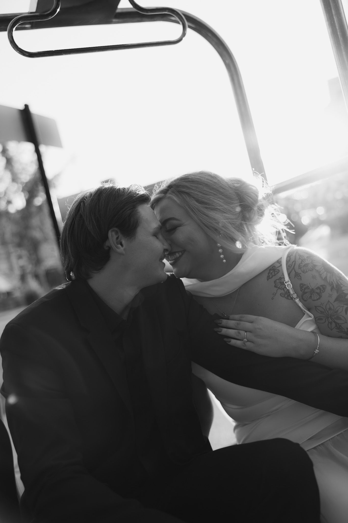 Intimate wedding moments captured inside a vehicle in black and white photography.