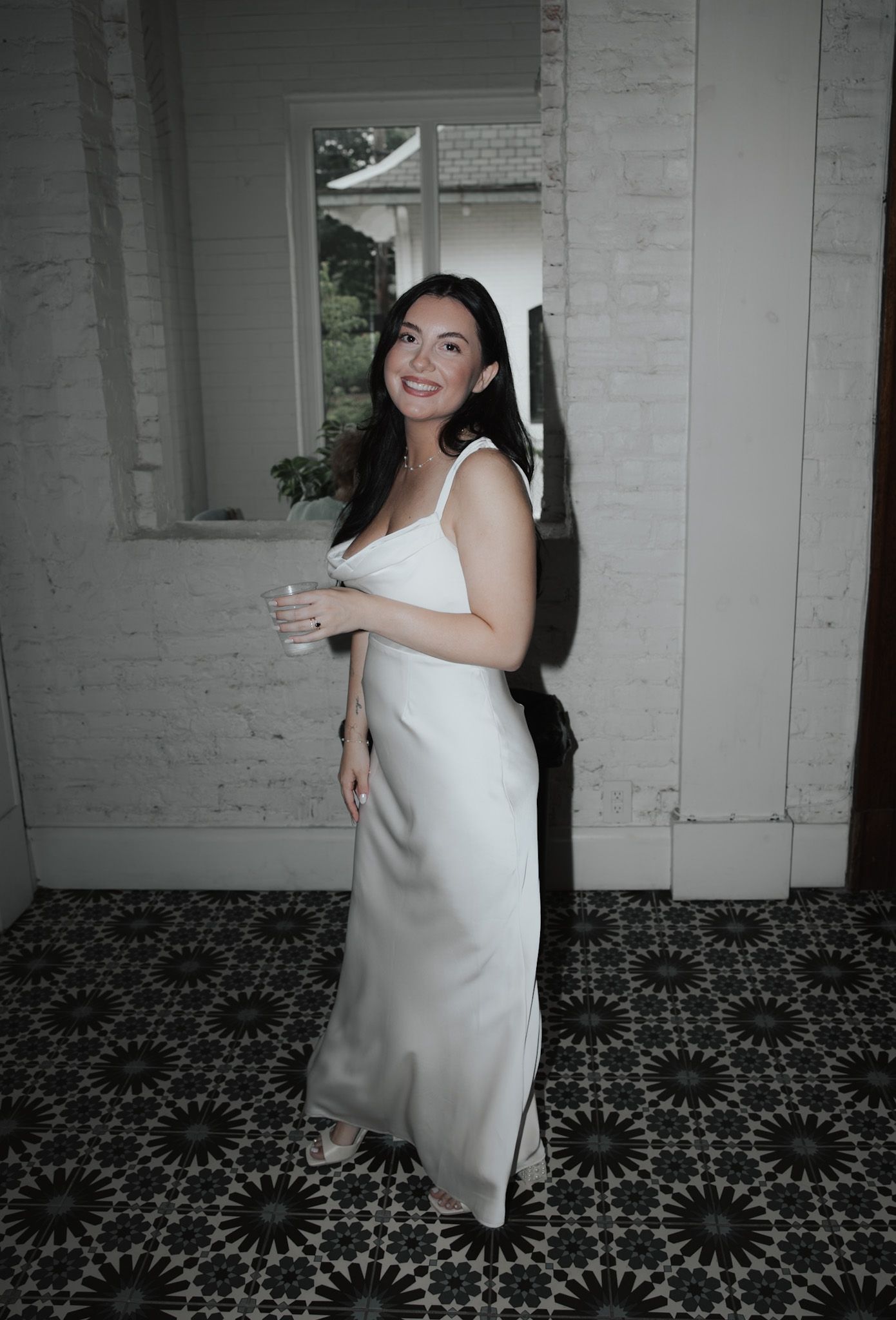 A person in white spins playfully on a patterned floor.