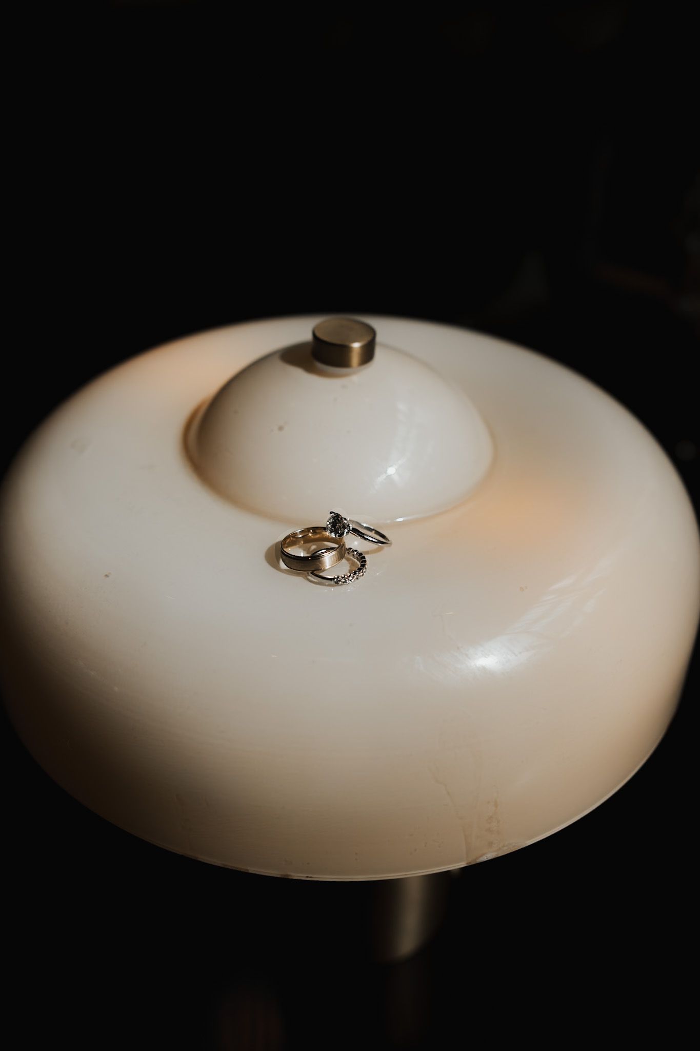 Artistic close-up of a white ceramic light fixture with metallic details.