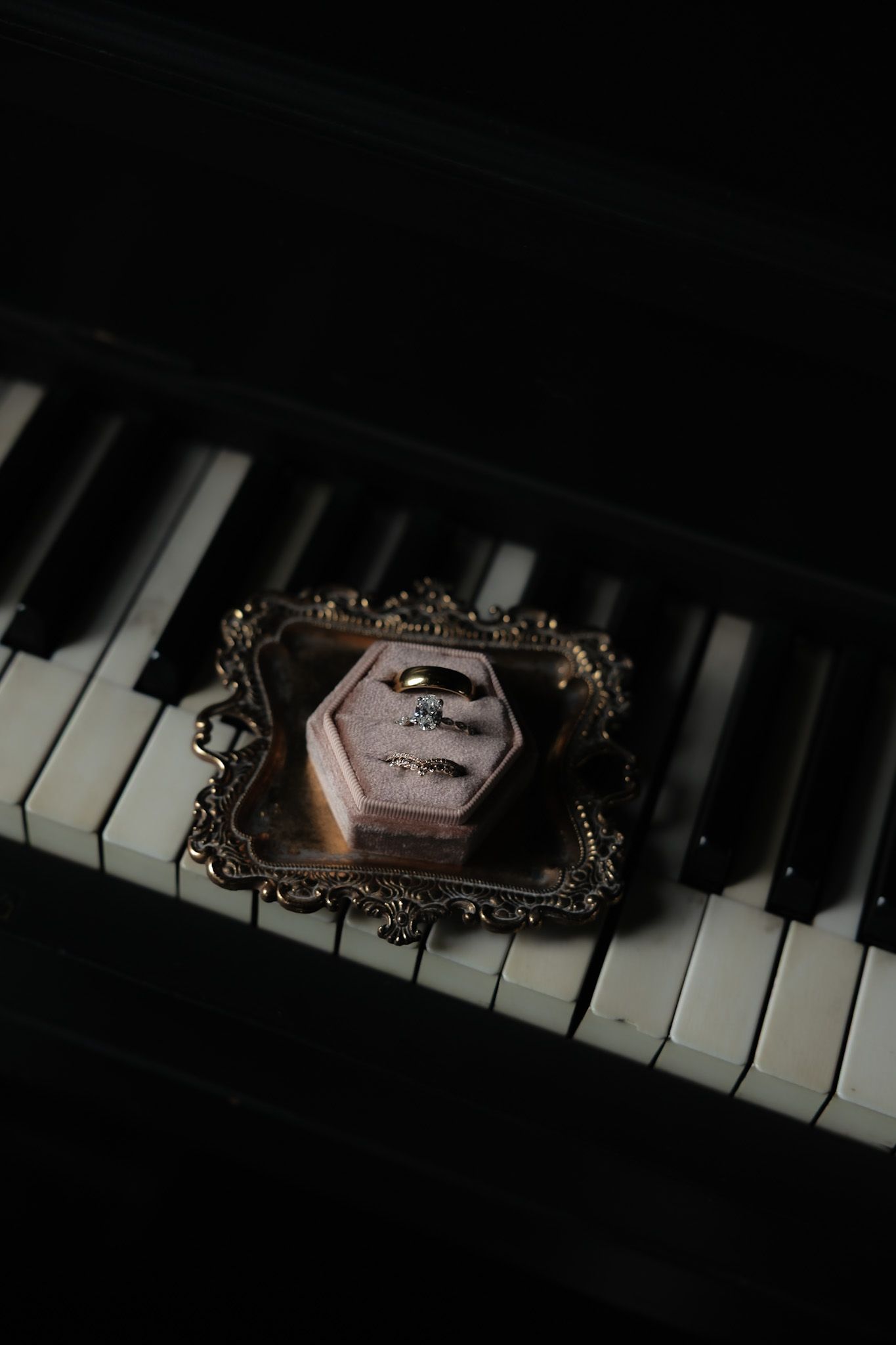 A vintage ornate frame sits dramatically on black and white piano keys.